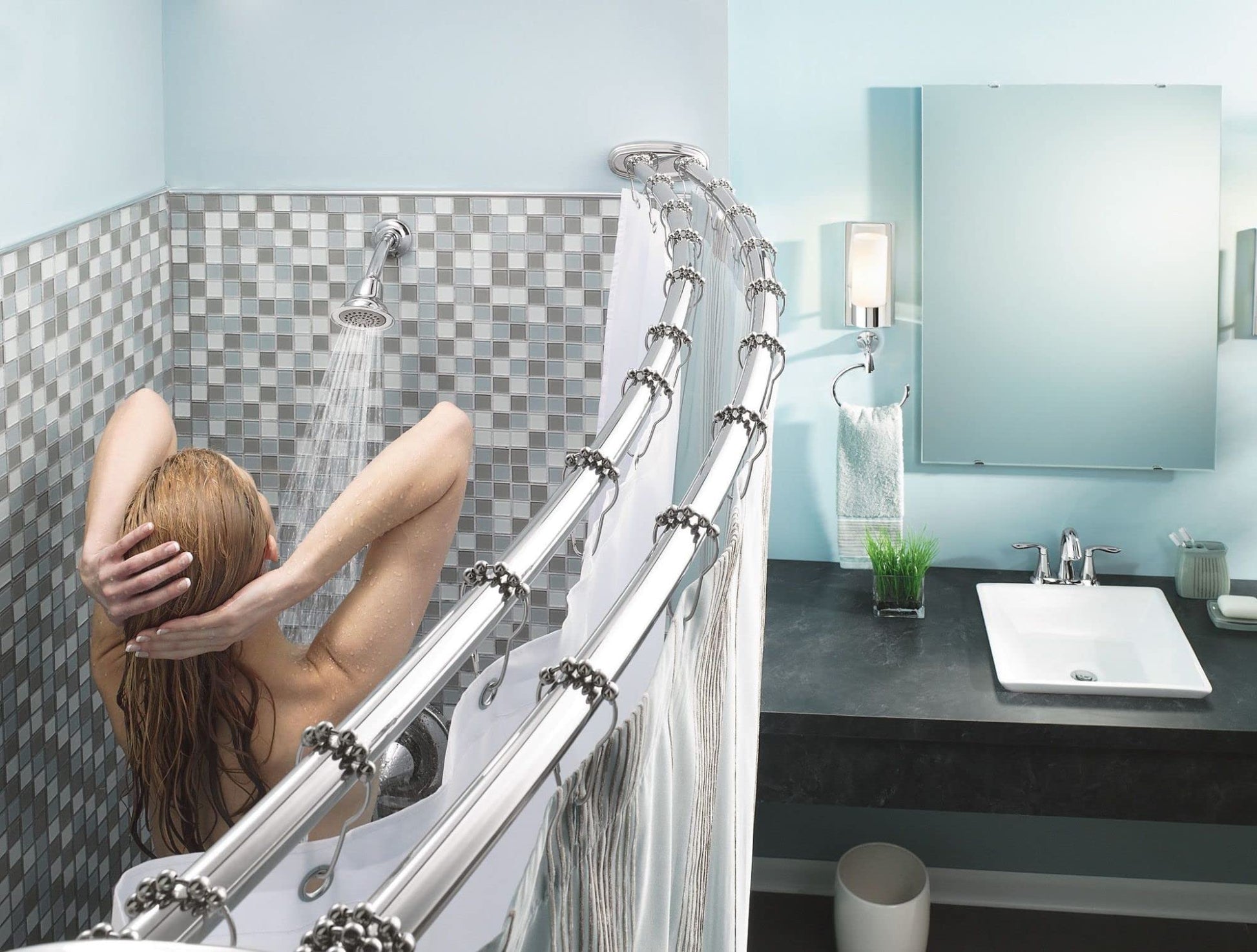Chrome wall-mounted towel ring installed in bathroom above bathtub edge next to shower curtain rod.