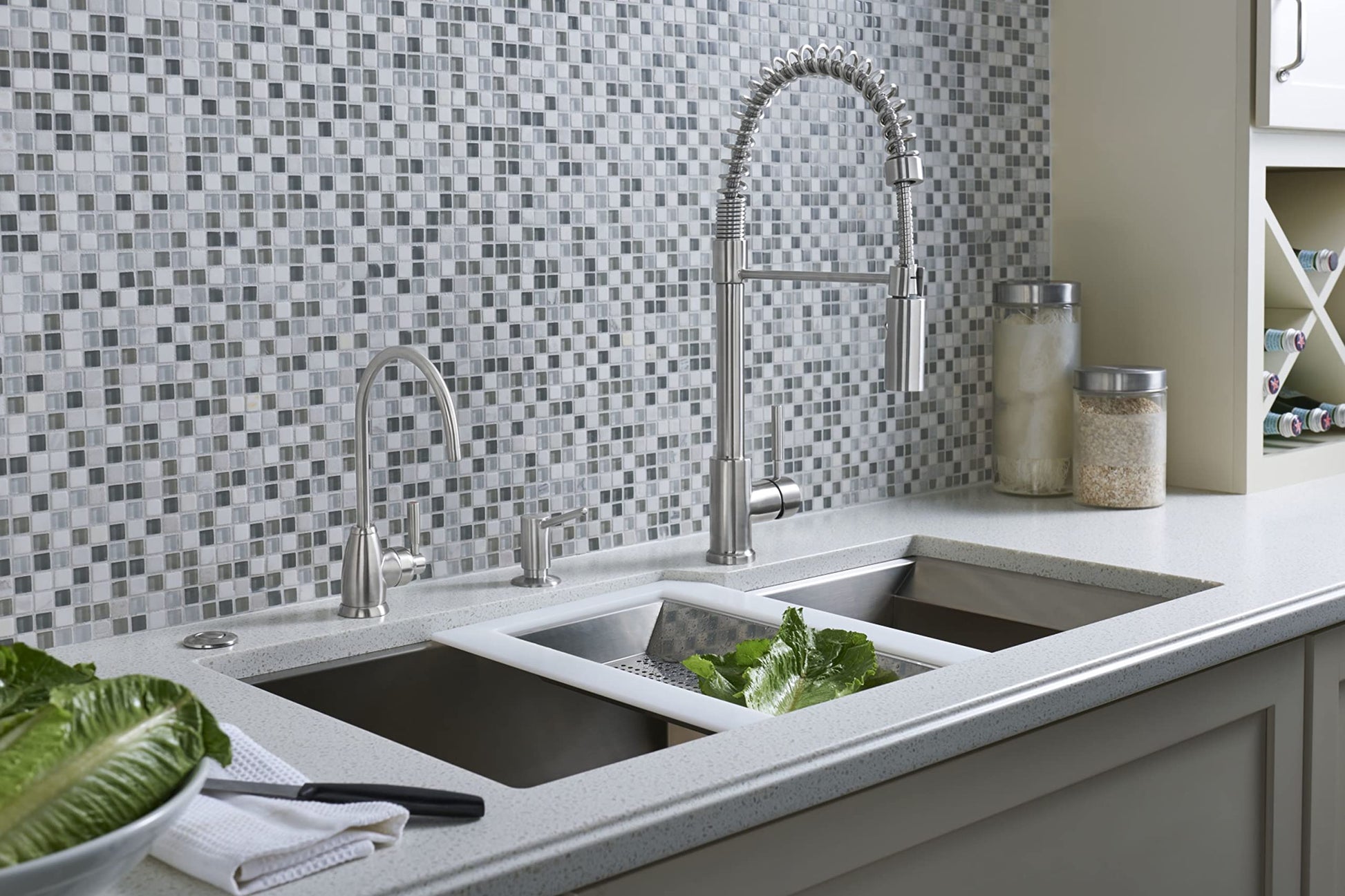 Satin English Gold hot water dispenser with curved spout mounted on kitchen countertop next to dual sink.