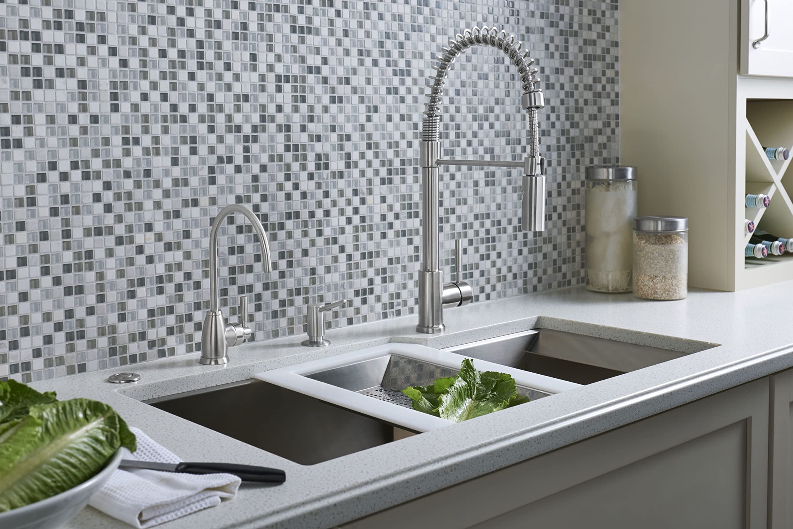 Satin English Gold hot water dispenser with curved spout mounted on kitchen countertop next to dual sink.