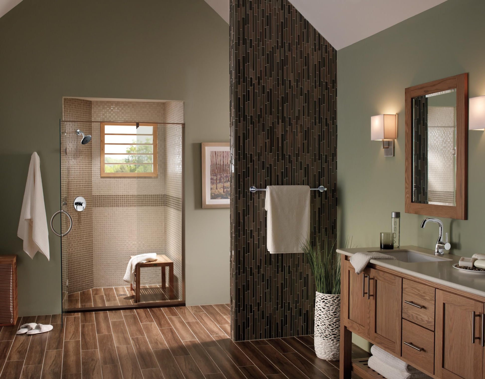 Chrome towel bar mounted horizontally on dark tile wall in bathroom.