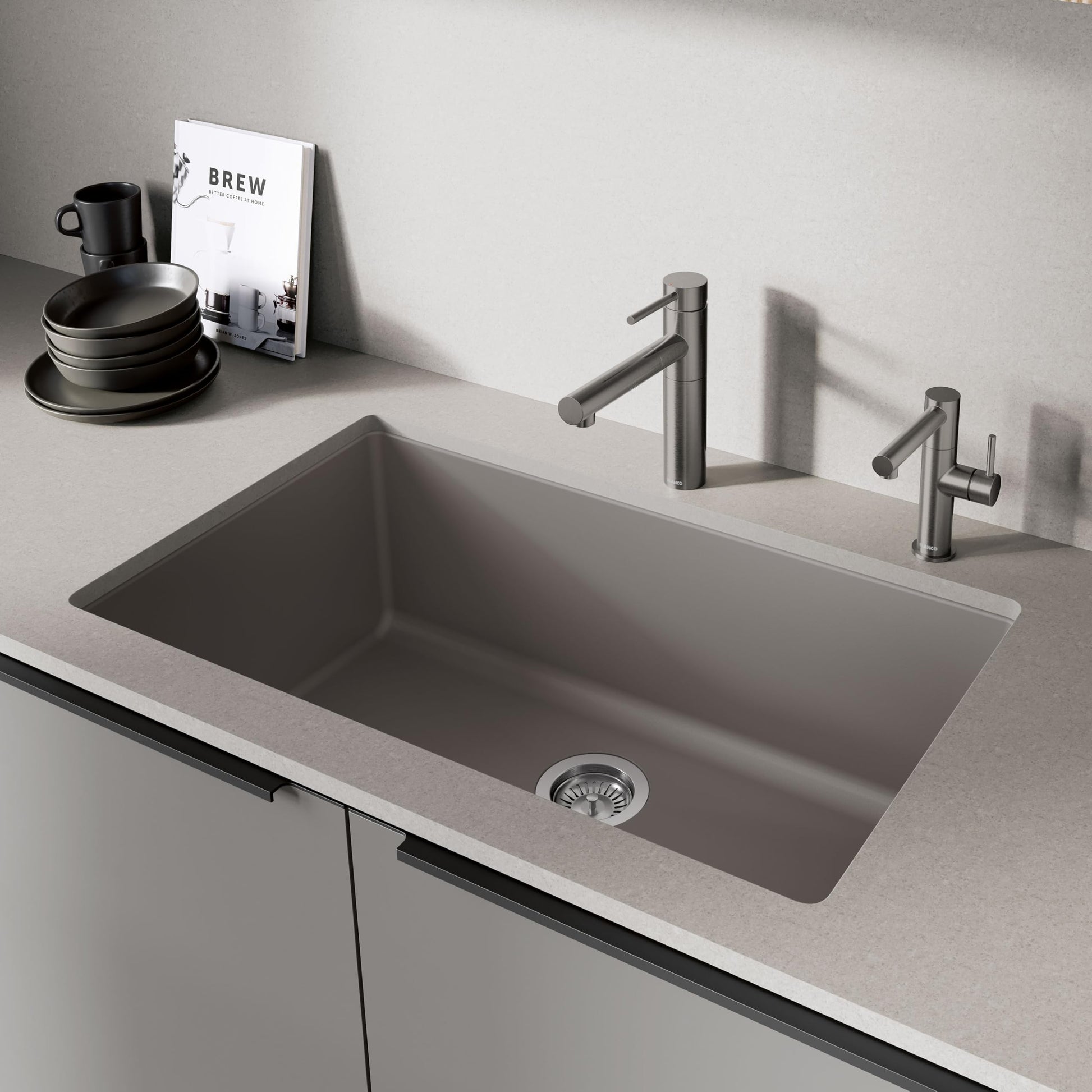Satin dark steel pull-out kitchen faucet installed above a rectangular undermount sink with matching metal finish.