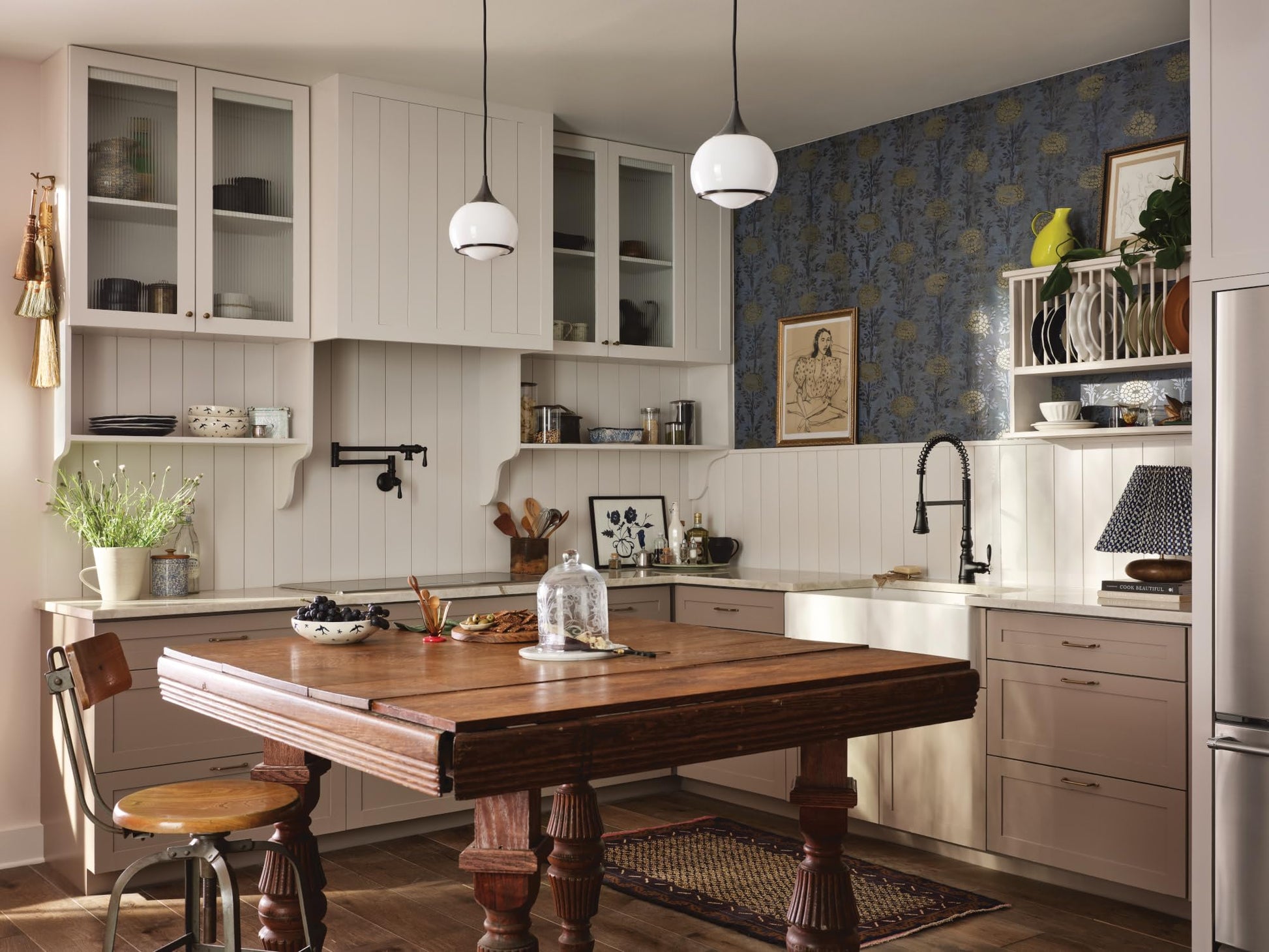 Matte black wall-mounted pot filler faucet with folding swing arm installed above kitchen counter.