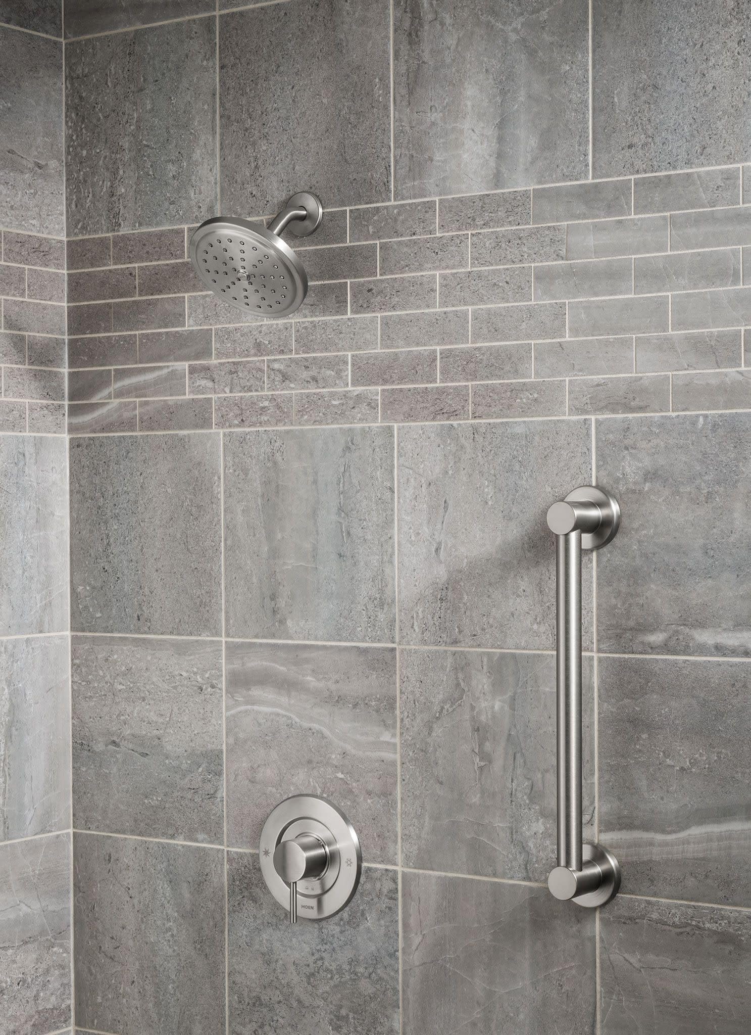 Brushed nickel stainless steel grab bar mounted horizontally on tiled bathroom wall next to shower fixtures.