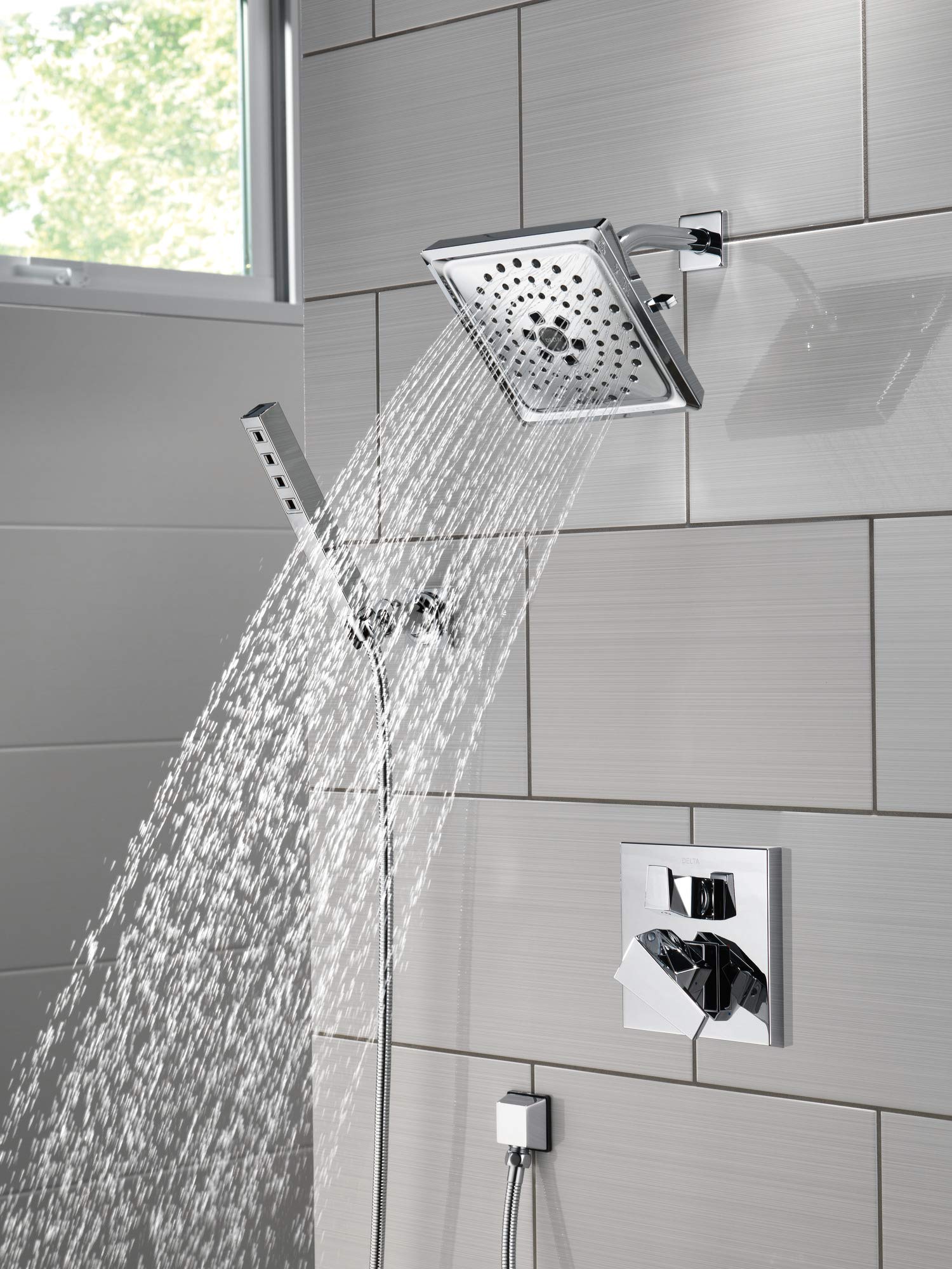 Black stainless steel shower flange with perforated square head mounted on tile wall with valve trim kit.