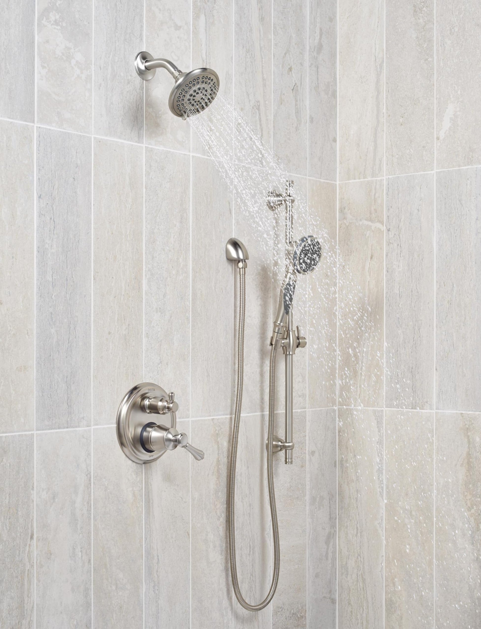Stainless steel raincan shower head with hand shower and flexible hose mounted on tile wall with control valve.