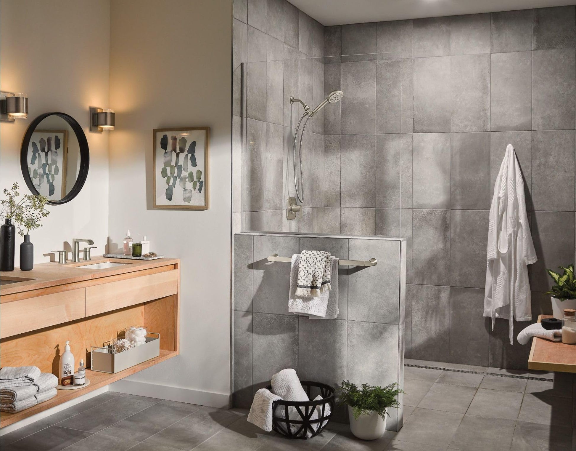 Brushed nickel wall-mounted towel bar with two folded white towels displayed in a modern gray tile bathroom.