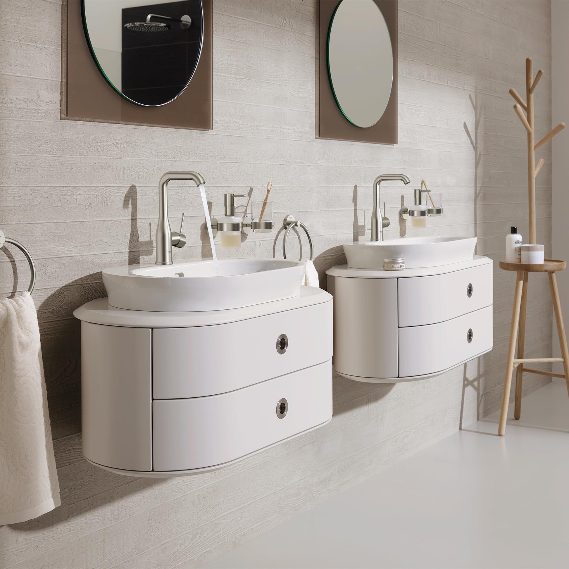 Brushed nickel single-handle bathroom faucet with curved spout installed on white vanity sink in modern bathroom setting.