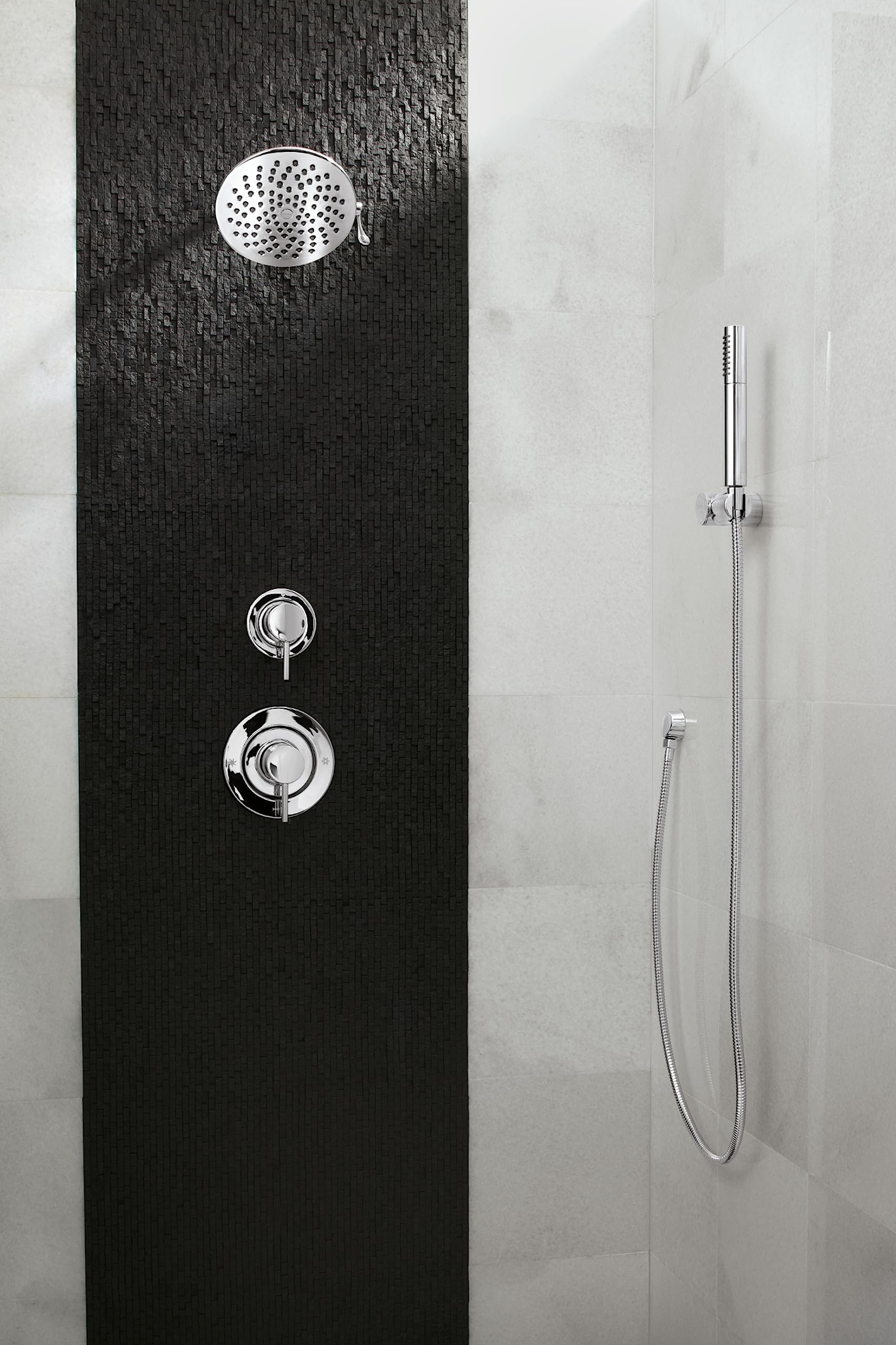 Chrome rain shower head mounted on black tile wall with dual control valves and handheld shower wand.