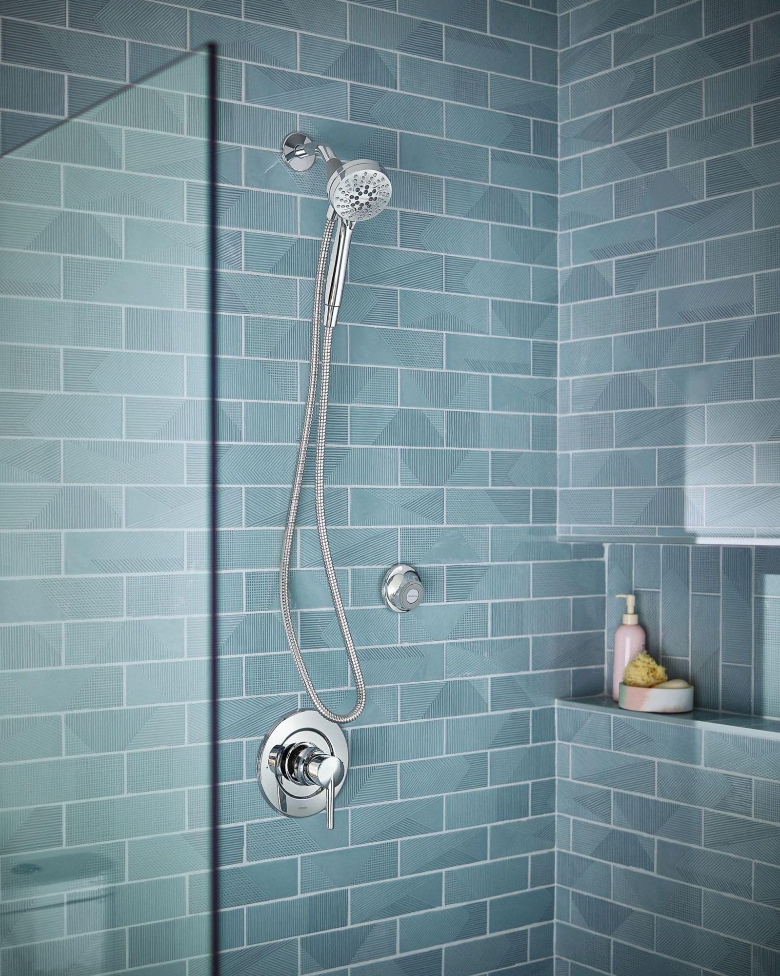 Chrome showerhead with flexible hose and magnetic cradle mounted on tile shower wall.