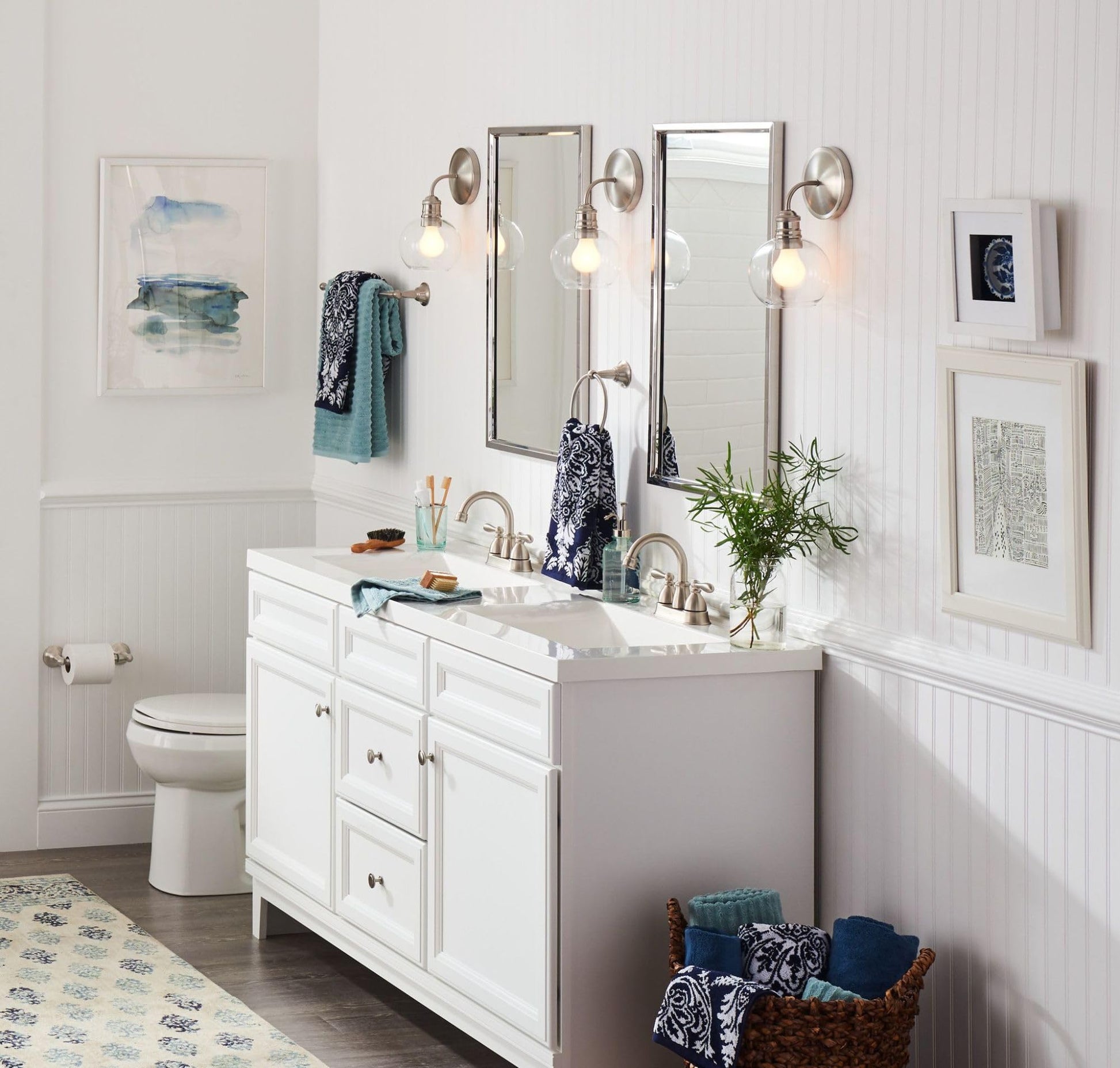 Brushed nickel wall-mount towel ring displayed on bathroom wall beside vanity sink.