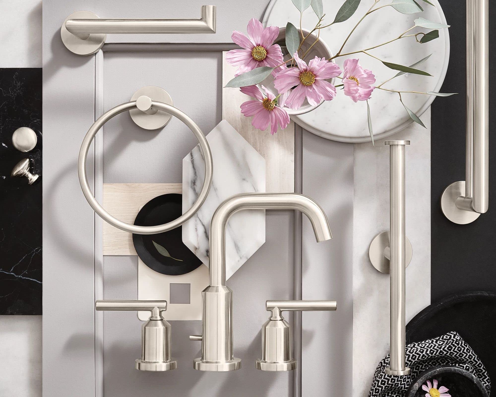 Brushed nickel double toilet paper holder with two horizontal bars mounted on white tile wall.