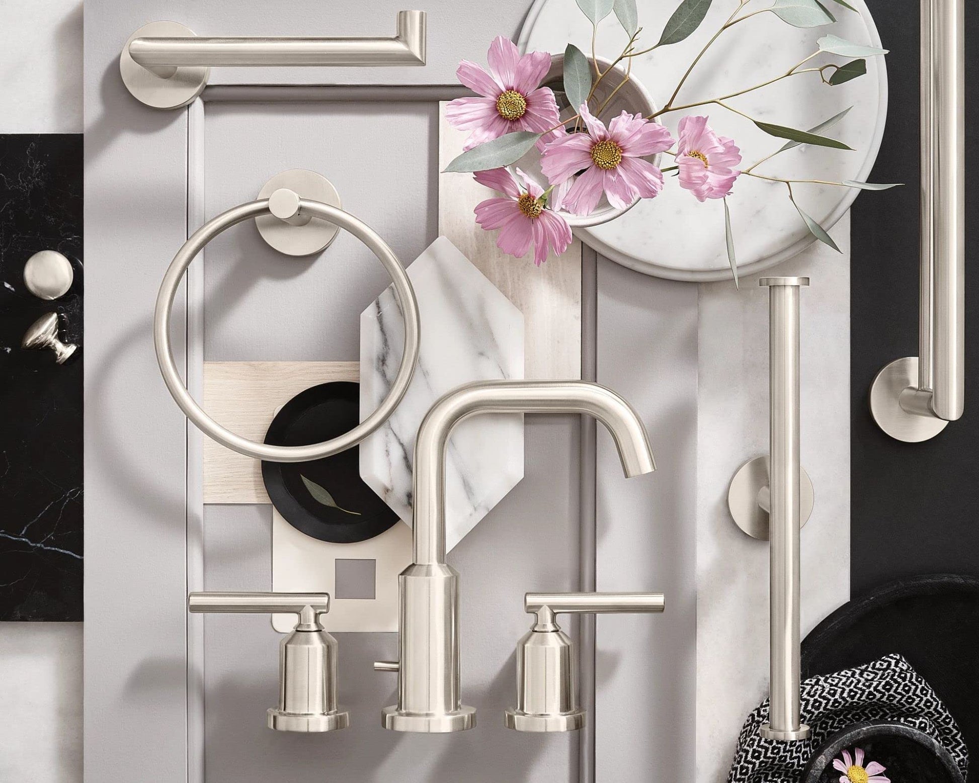 Brushed nickel double towel bar with modern design mounted on white bathroom wall.