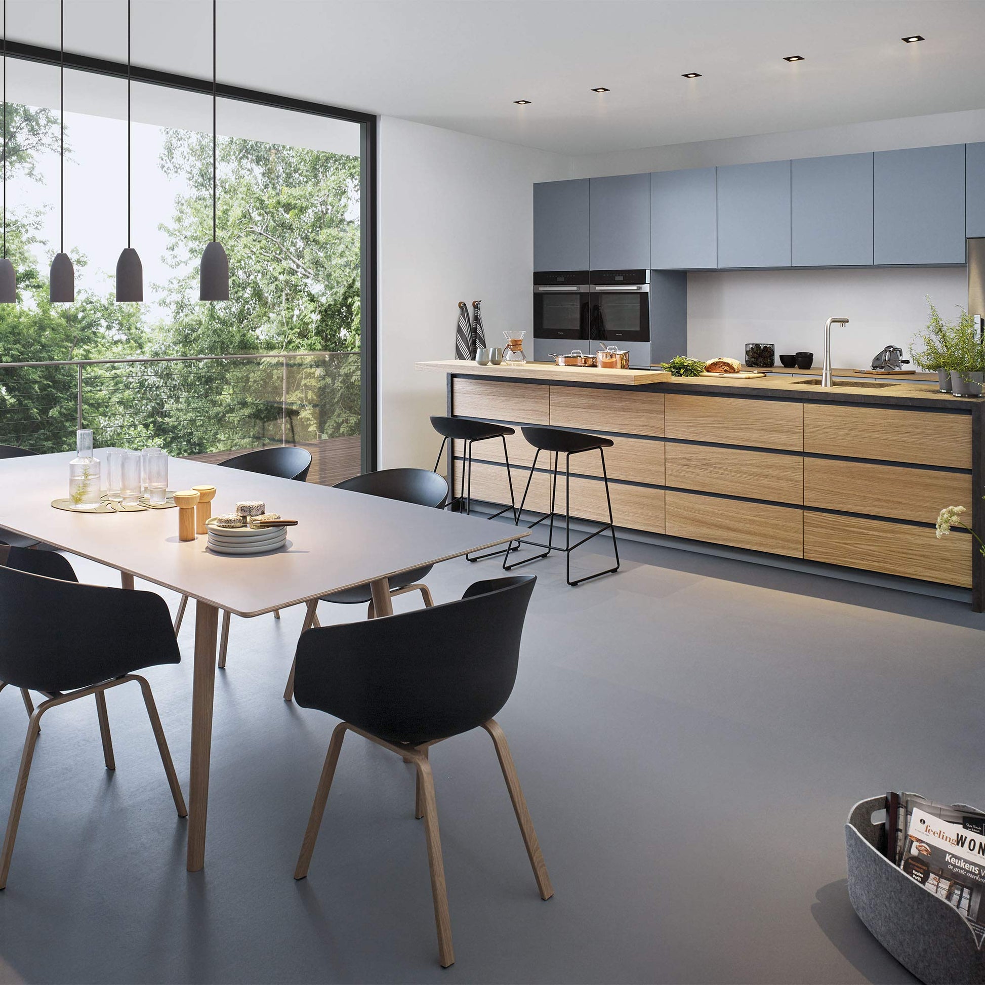 Chrome pull-out kitchen faucet with single spray head mounted on wooden countertop in modern kitchen.