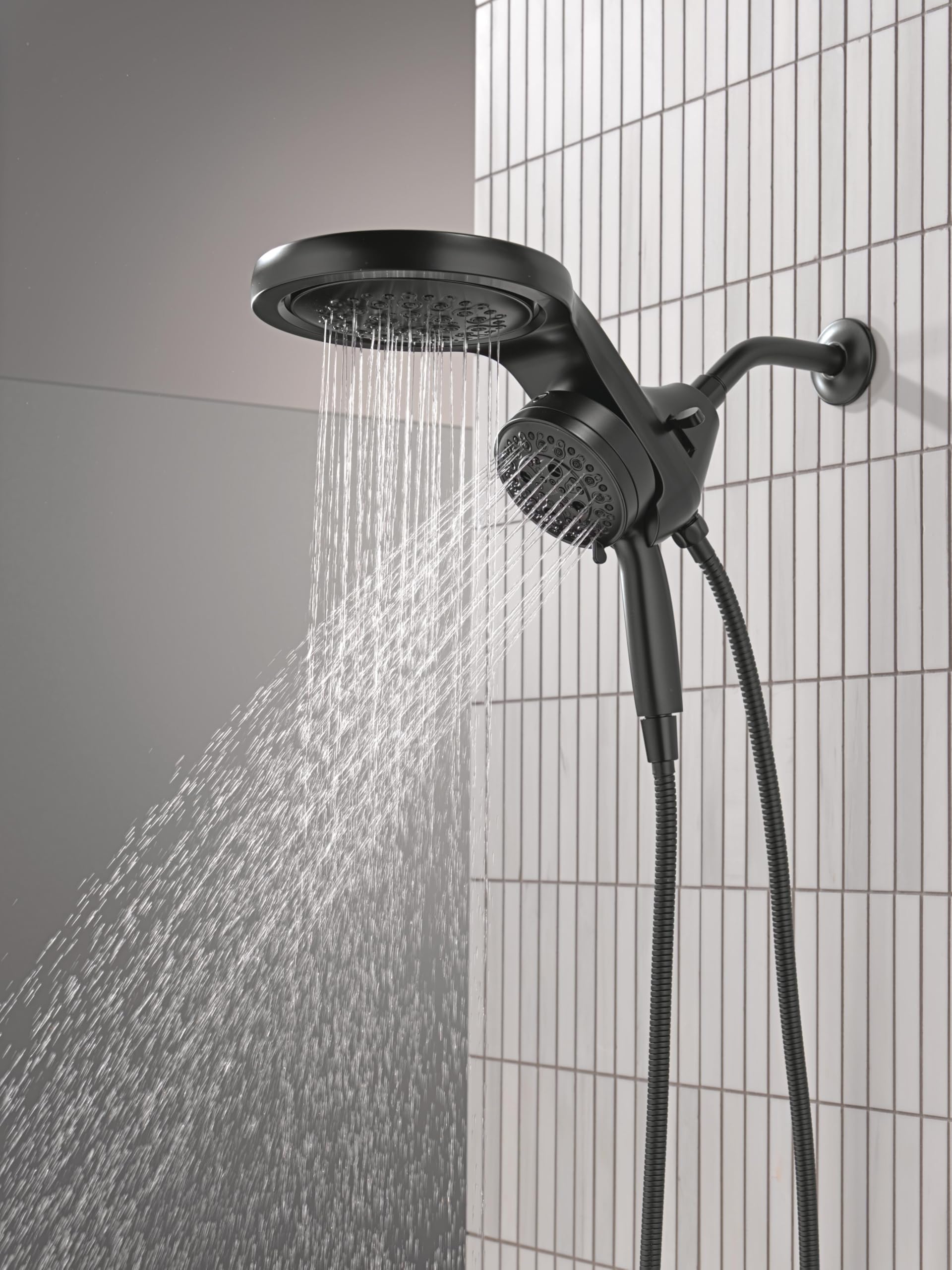 Matte black dual showerhead system with overhead rainfall nozzle and handheld spray mounted on tiled shower wall.