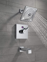 Champagne bronze tub spout with pull-up diverter mounted on tile wall with shower head and control valve.