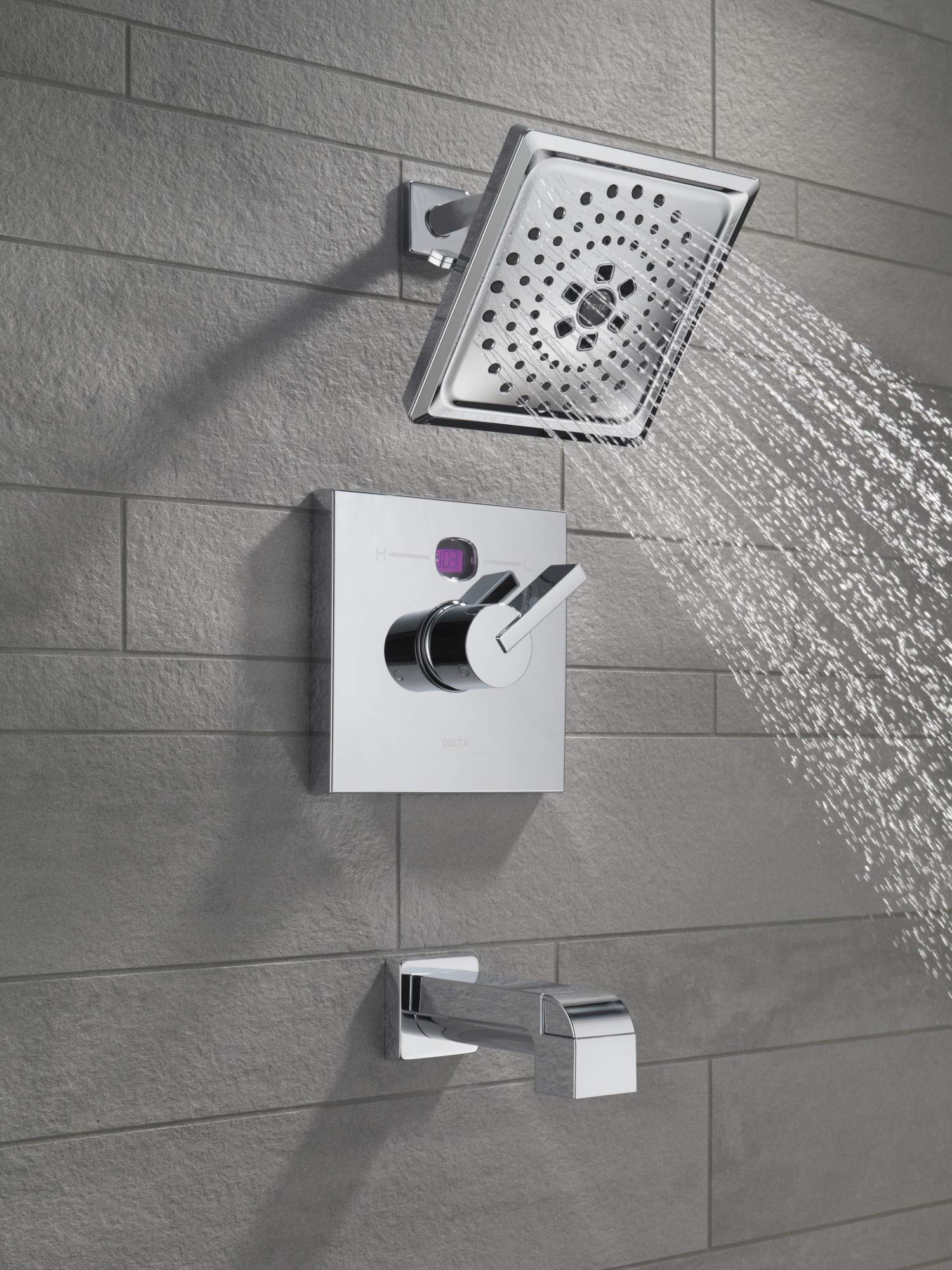 Champagne bronze tub spout with pull-up diverter mounted on tile wall with shower head and control valve.