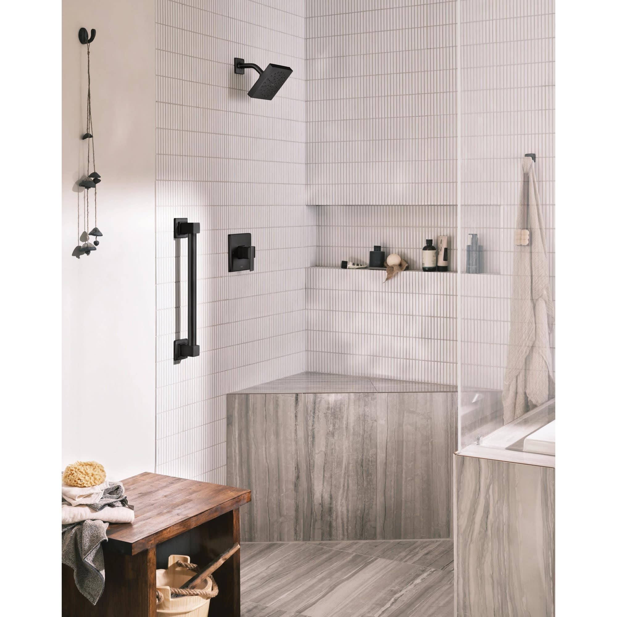 Brushed nickel single-handle shower trim kit with square showerhead and handheld wand mounted on white subway tile wall.