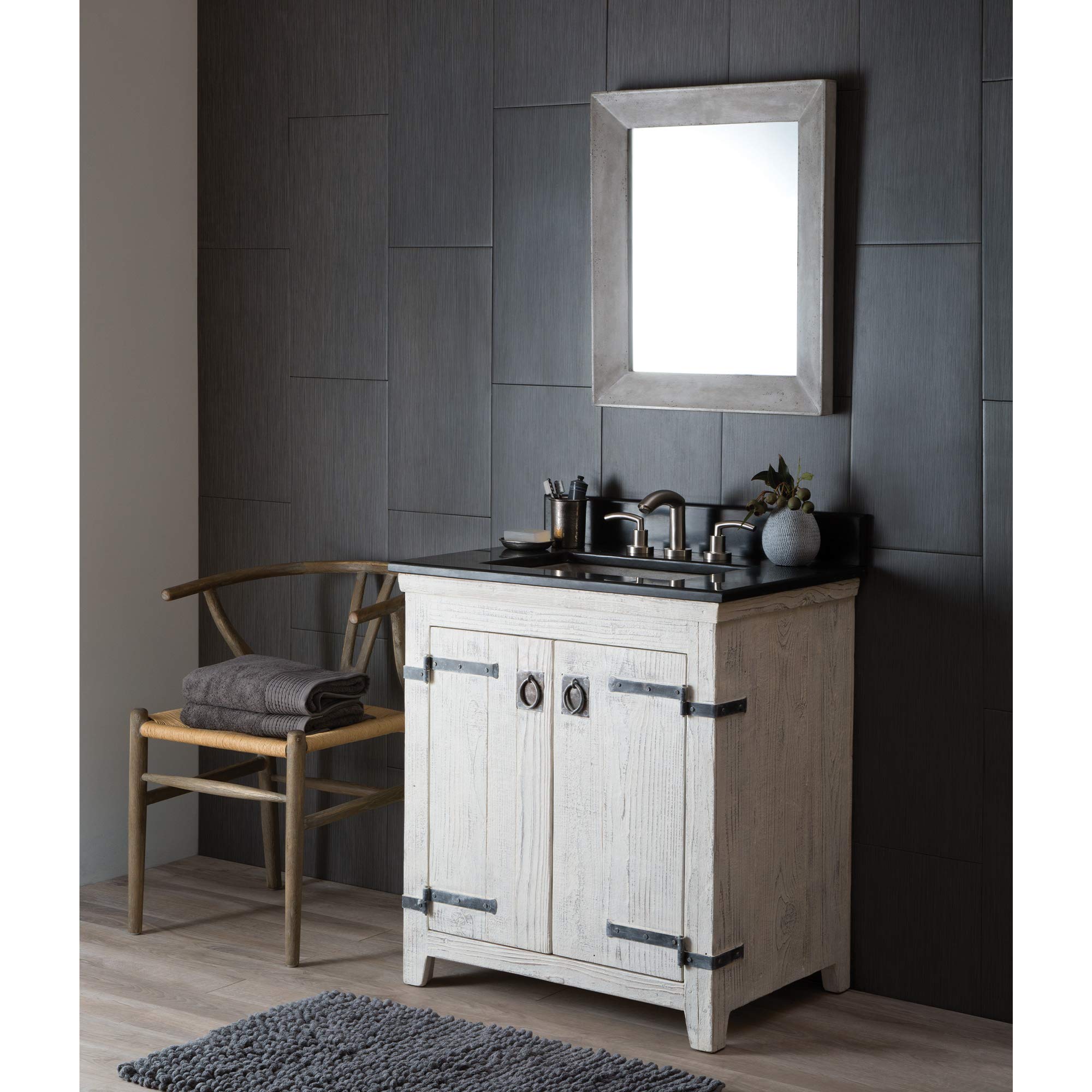 Rectangular mirror with ash-colored wooden frame mounted on dark textured wall above bathroom vanity.