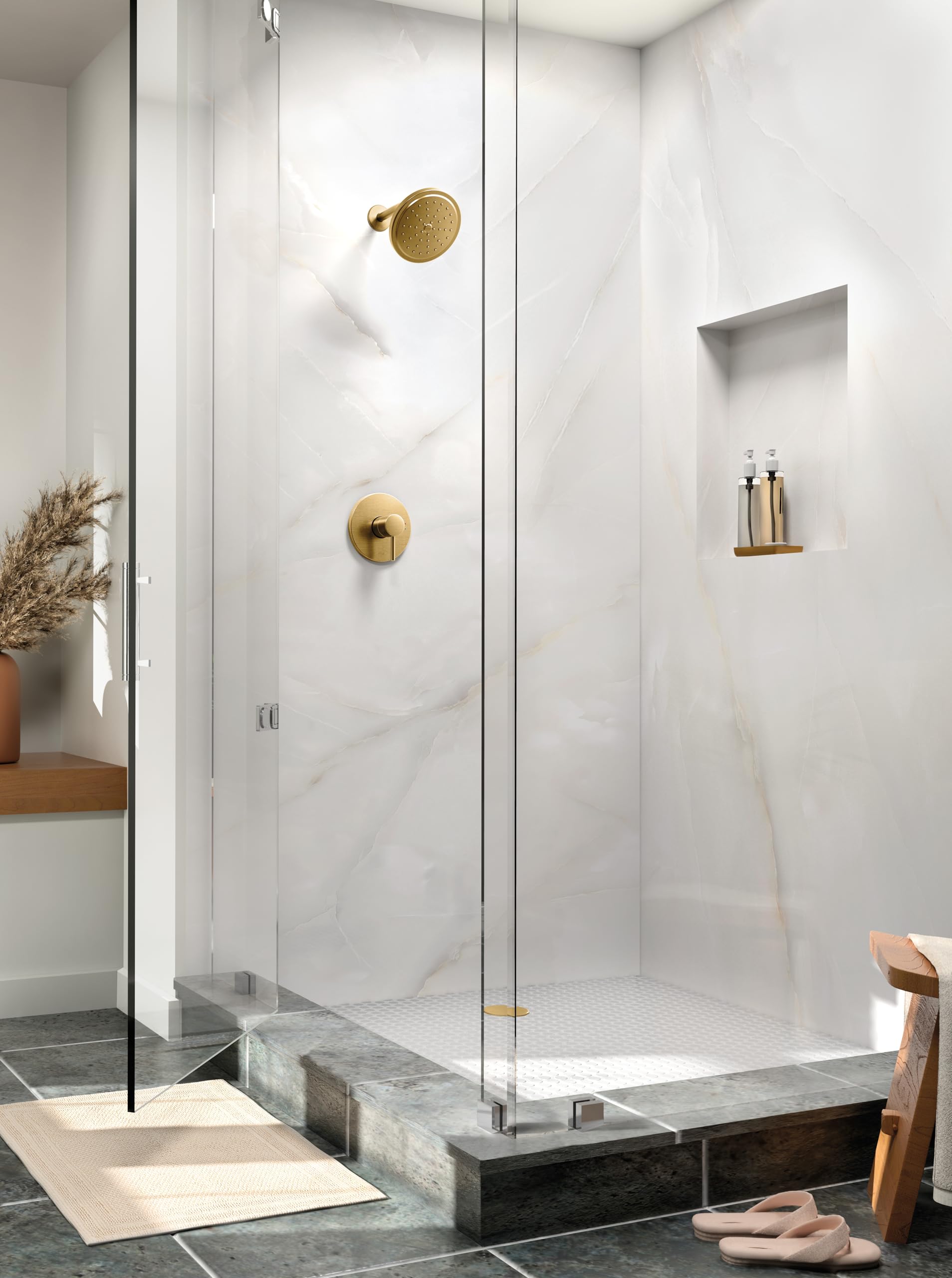 Brushed gold single-handle shower valve and round showerhead mounted on marble tile wall in modern bathroom enclosure.