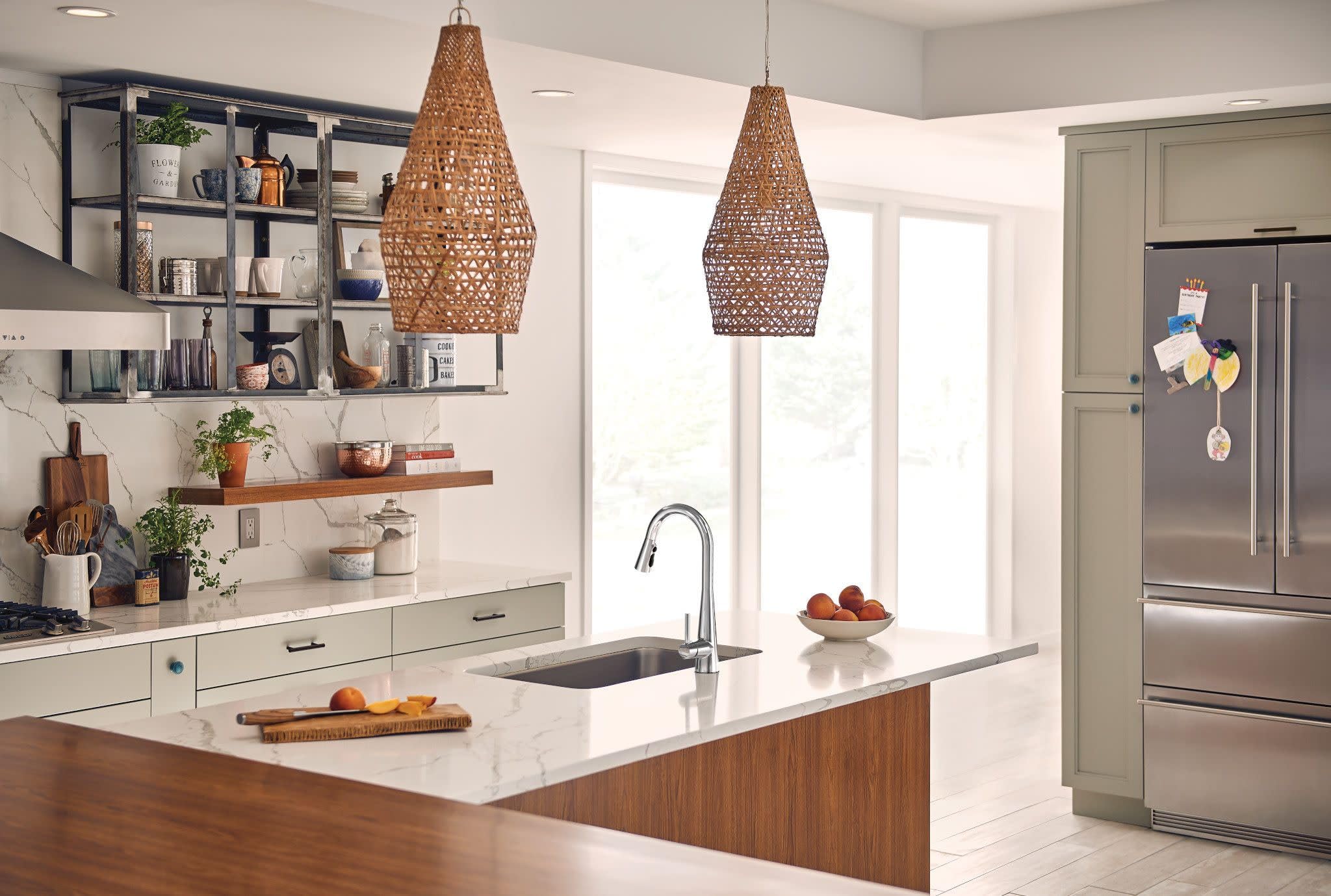 Chrome single-handle high arc pulldown kitchen faucet with curved spout installed above island sink.