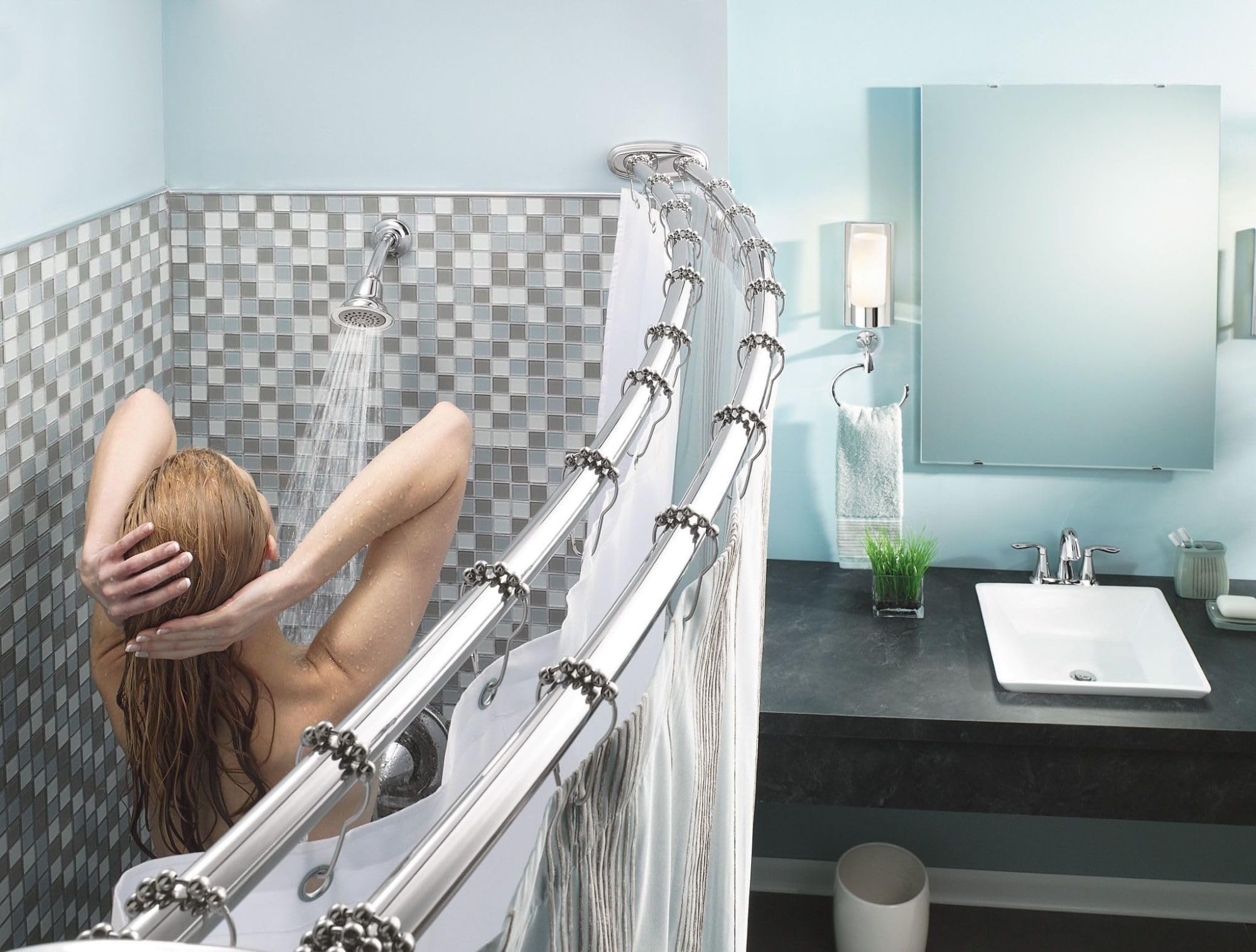 Chrome wall-mount towel ring installed above bathtub edge in bathroom with checkered tile surround.