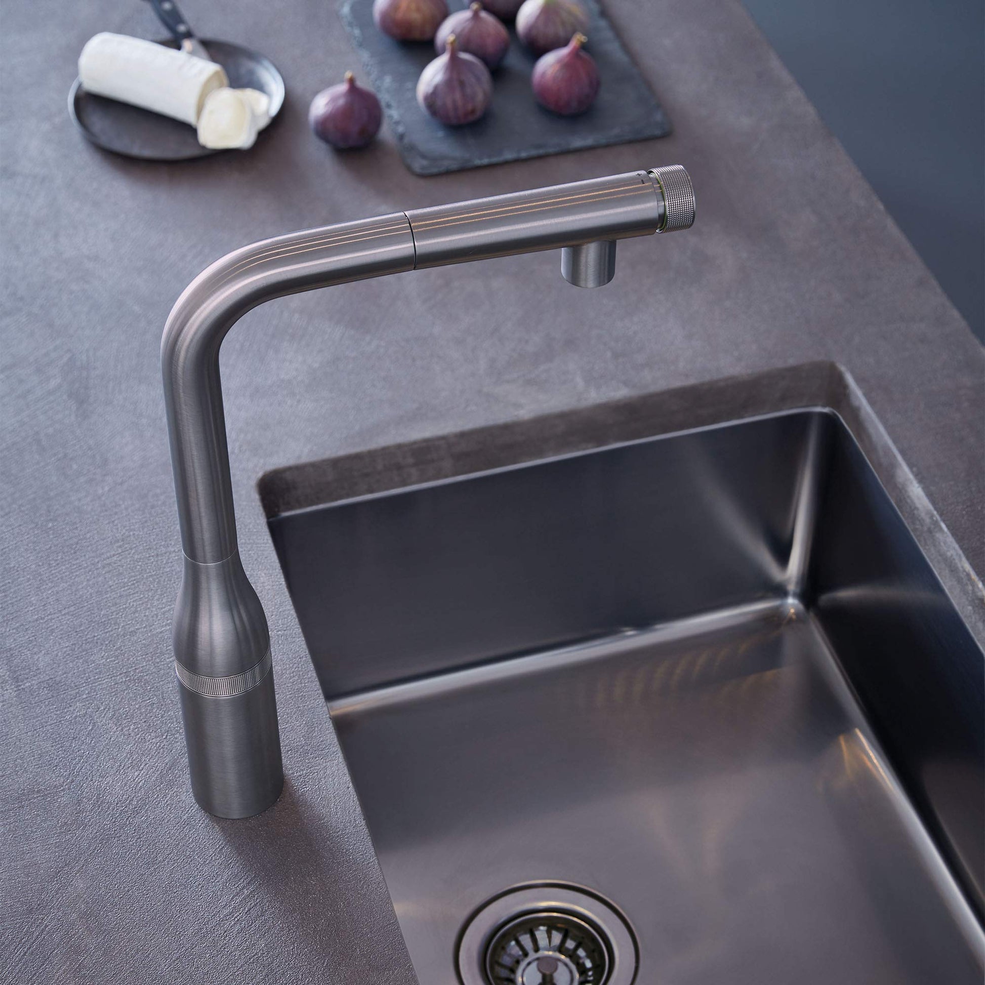 Grohe Supersteel pull-out kitchen faucet with curved spout mounted above stainless steel sink.