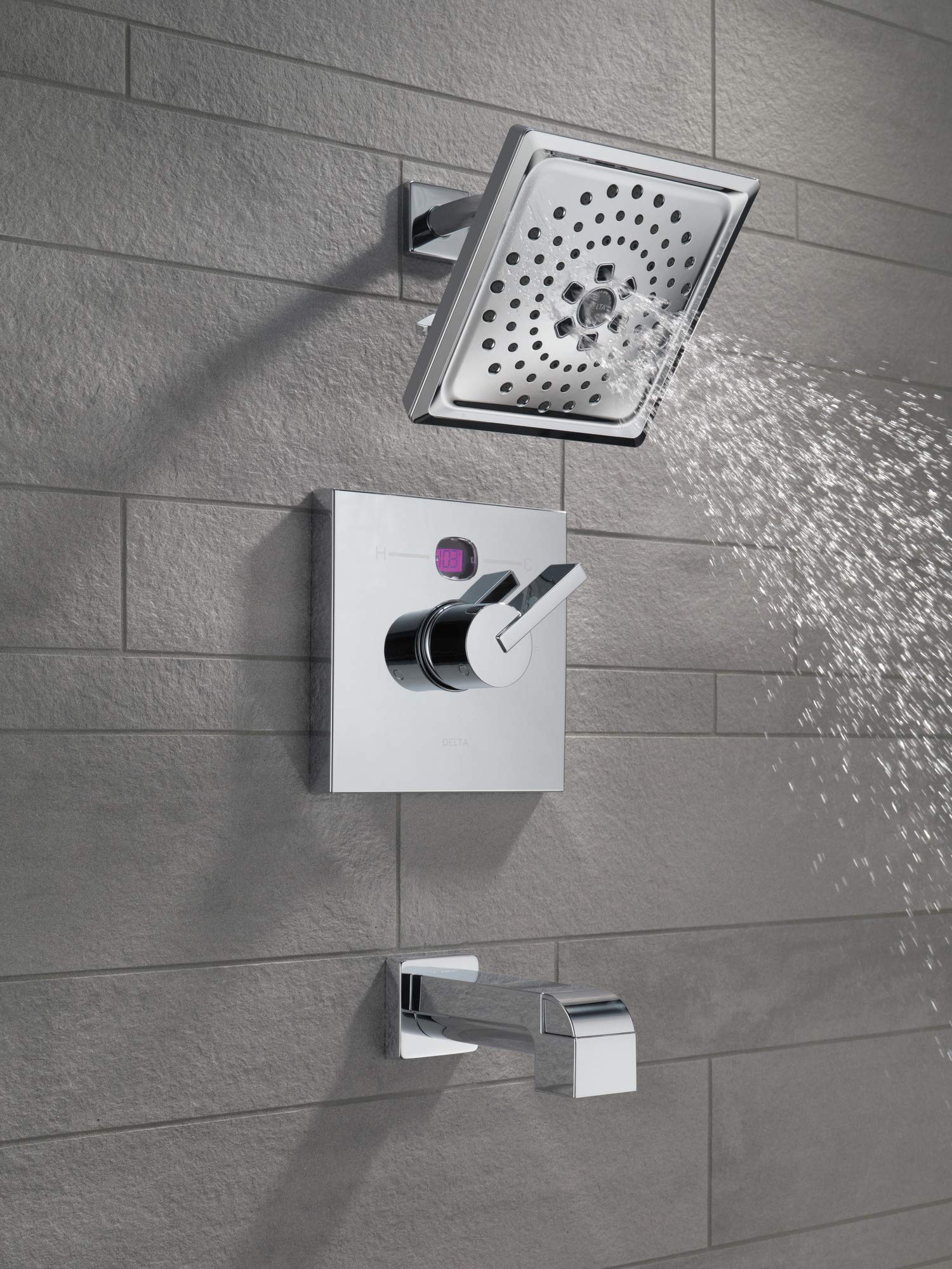 Black stainless shower arm with square head mounted on tile wall, water spraying from perforations.
