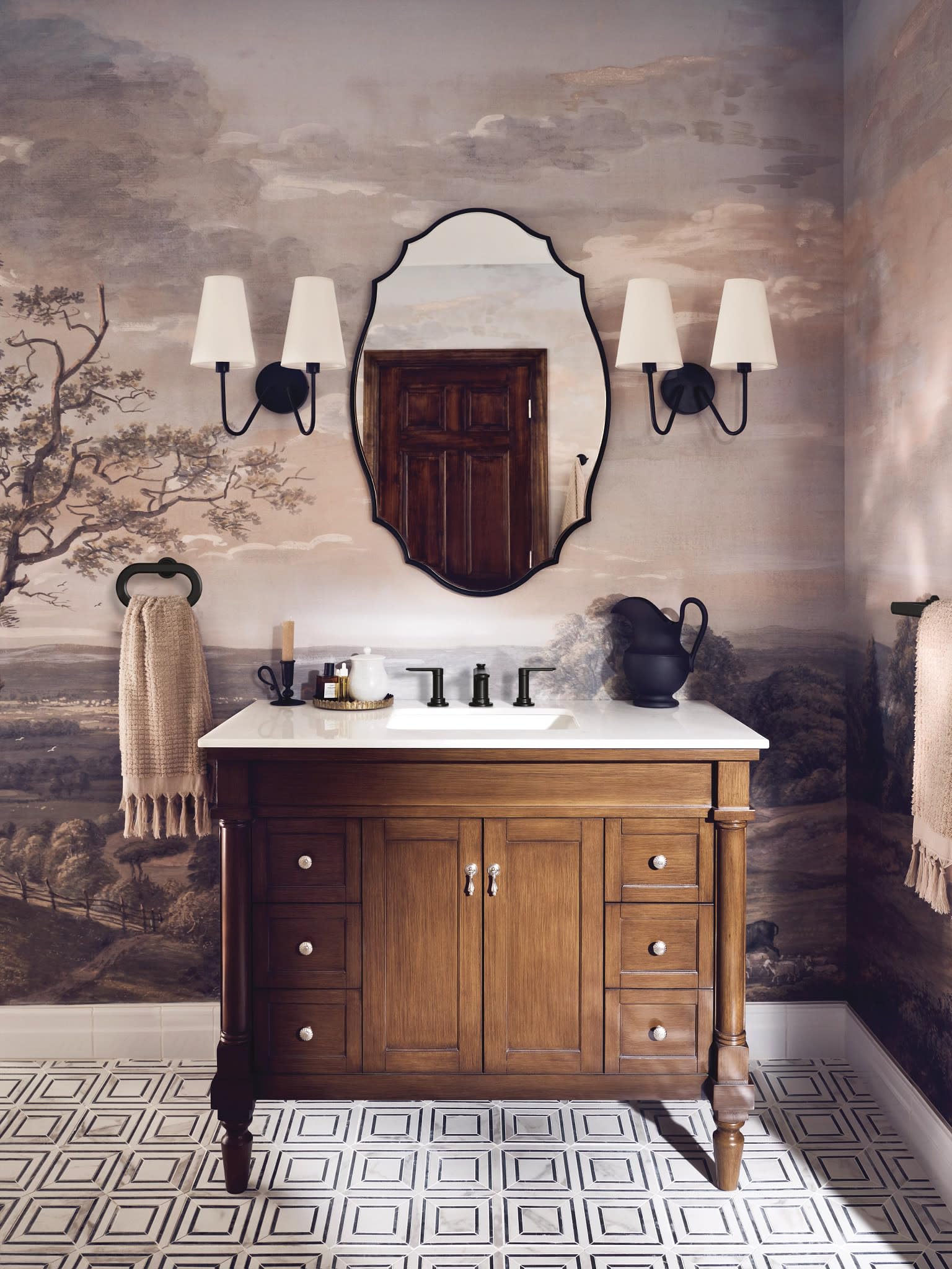 Matte black two-handle widespread bathroom sink faucet installed on white sink with matte black handles and spout.
