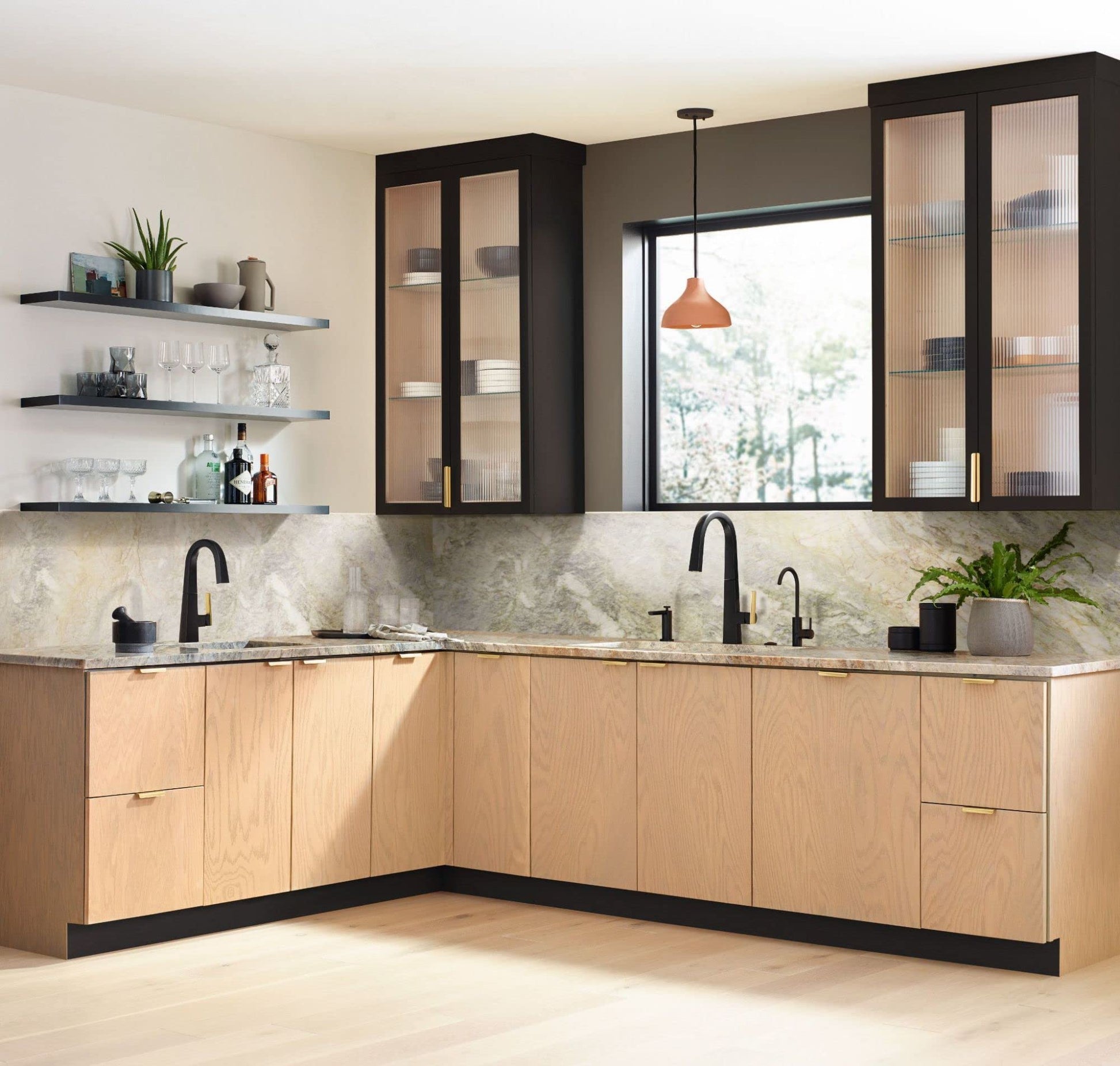 Moen Sip matte black cold water kitchen faucet with curved spout installed on marble countertop.