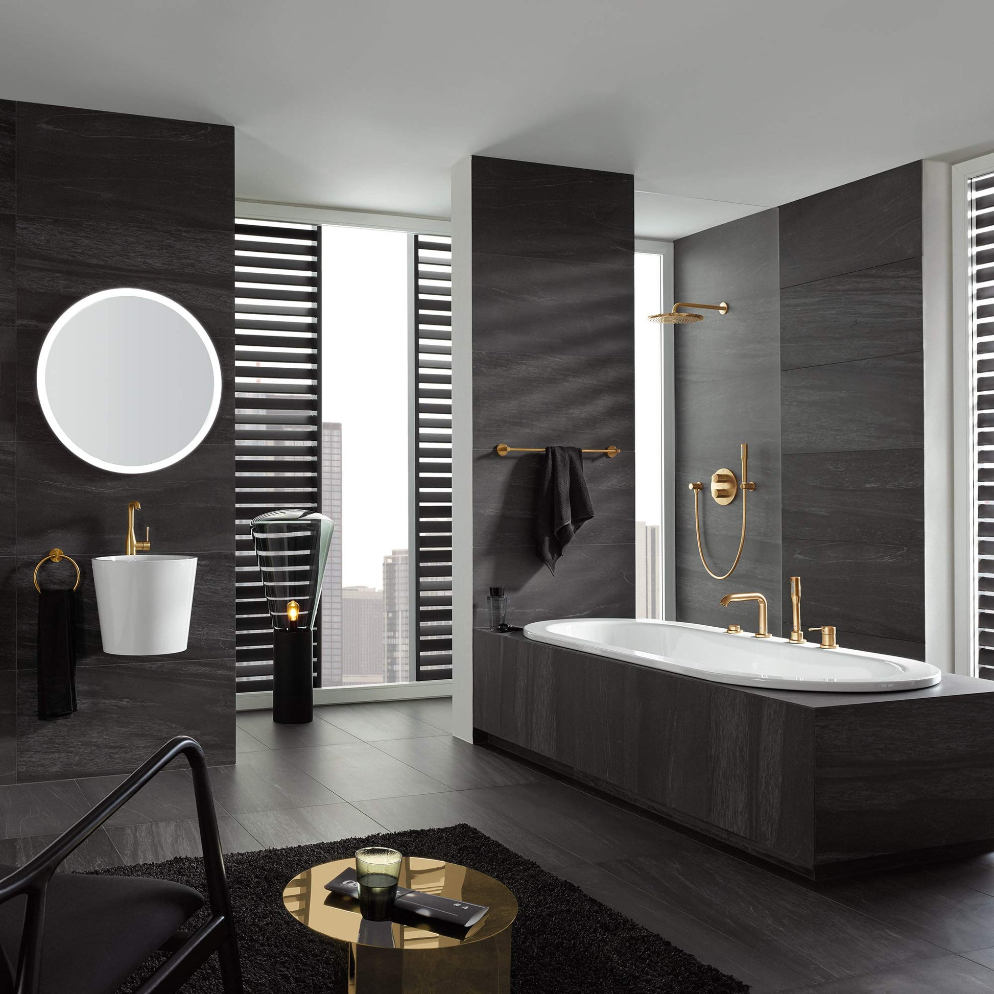 Dark graphite deck-mount Roman tub faucet with single handle and matching hand shower in modern bathroom setting.