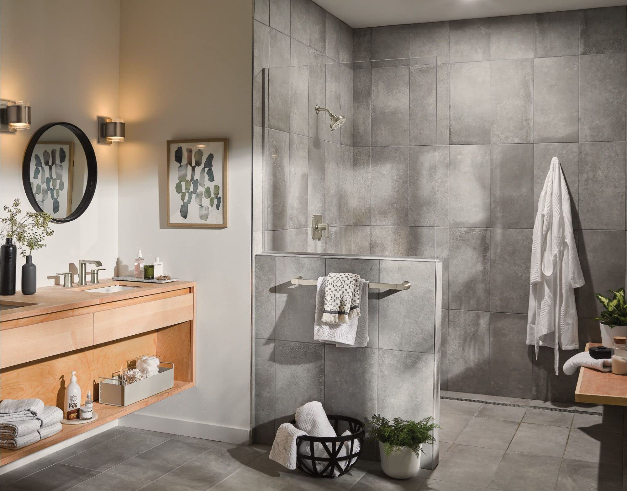 Brushed nickel shower valve trim with single handle mounted on gray tile shower wall.