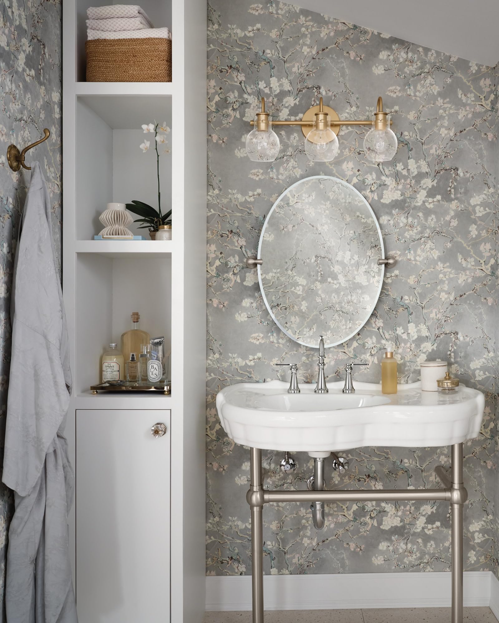 Chrome two-handle widespread bathroom faucet with high arc spout and lever handles installed on white pedestal sink.