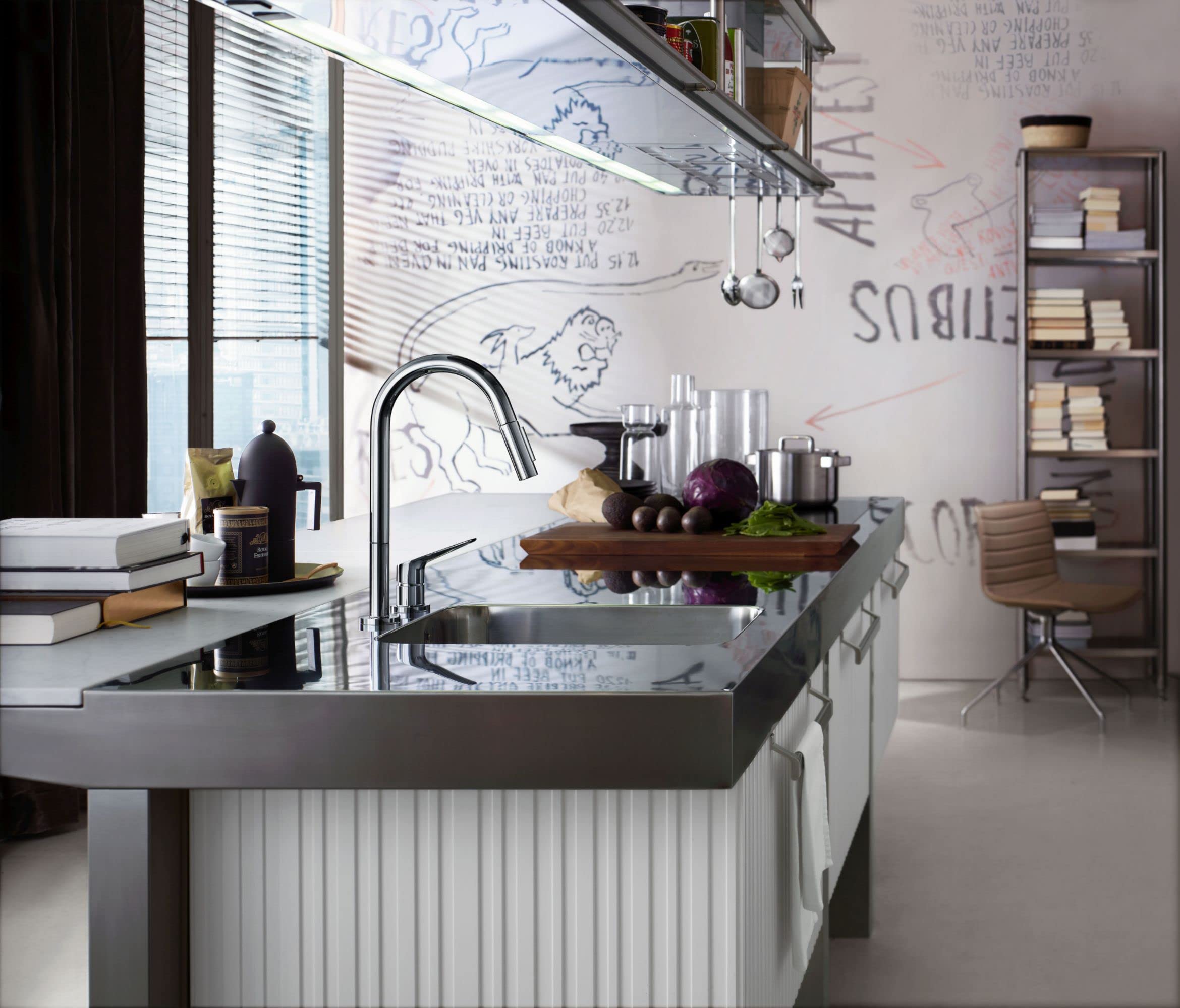 Steel optic pull-down kitchen faucet with single handle mounted above stainless steel sink in modern kitchen.