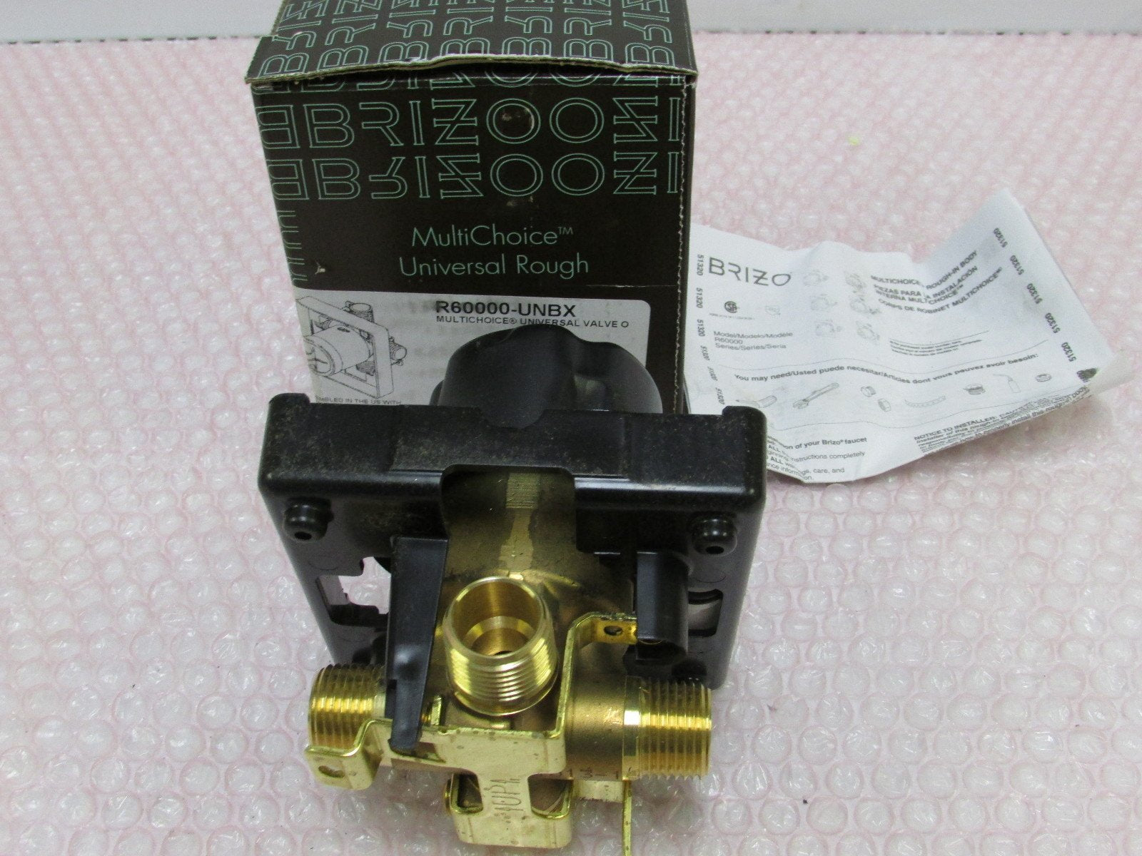 Brizo R60000-UNBX MultiChoice Universal rough valve with brass connections and black housing, shown with packaging and instru