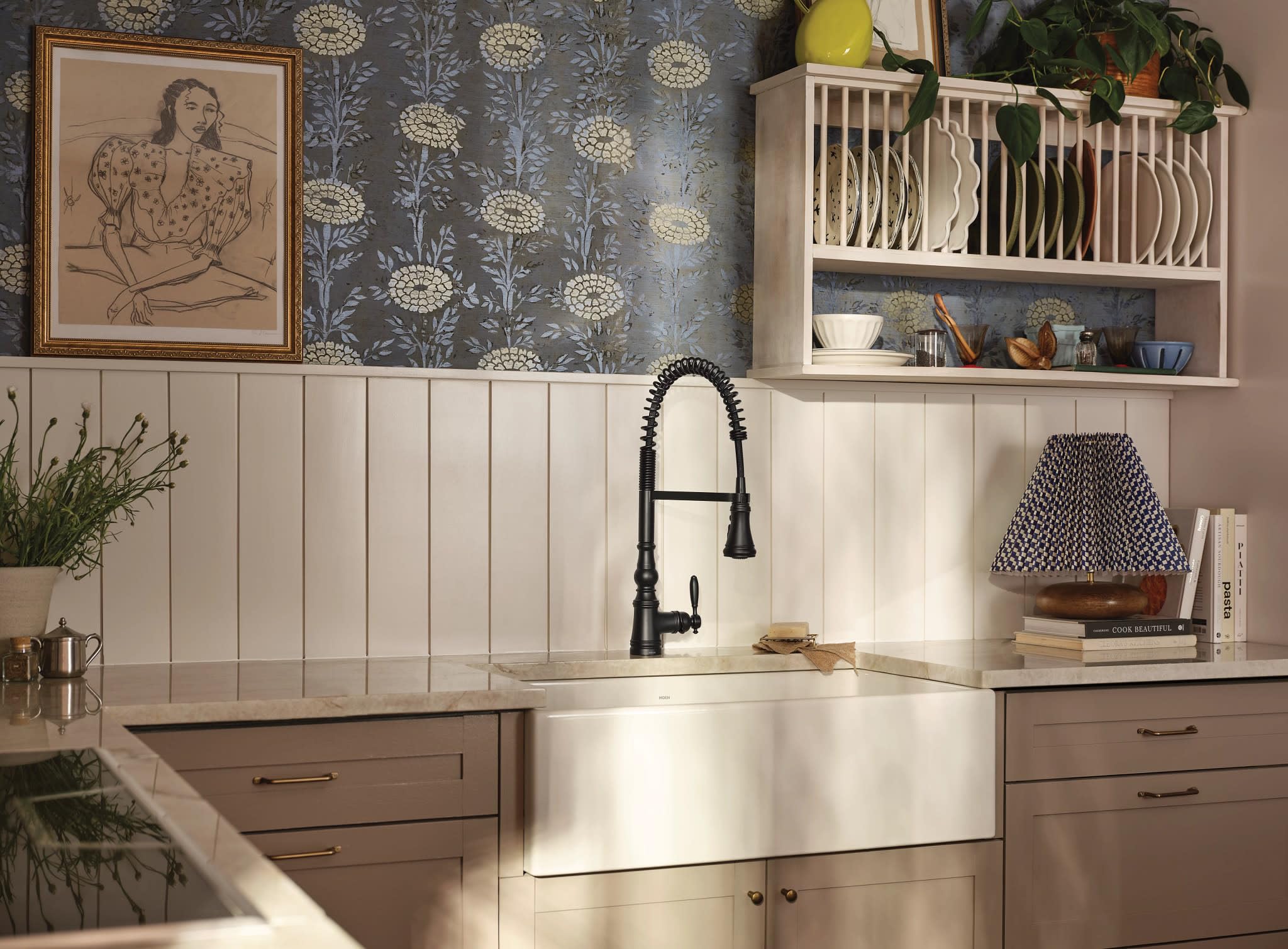 Matte black single-handle pulldown kitchen faucet with coiled spring spout installed above white farmhouse sink.