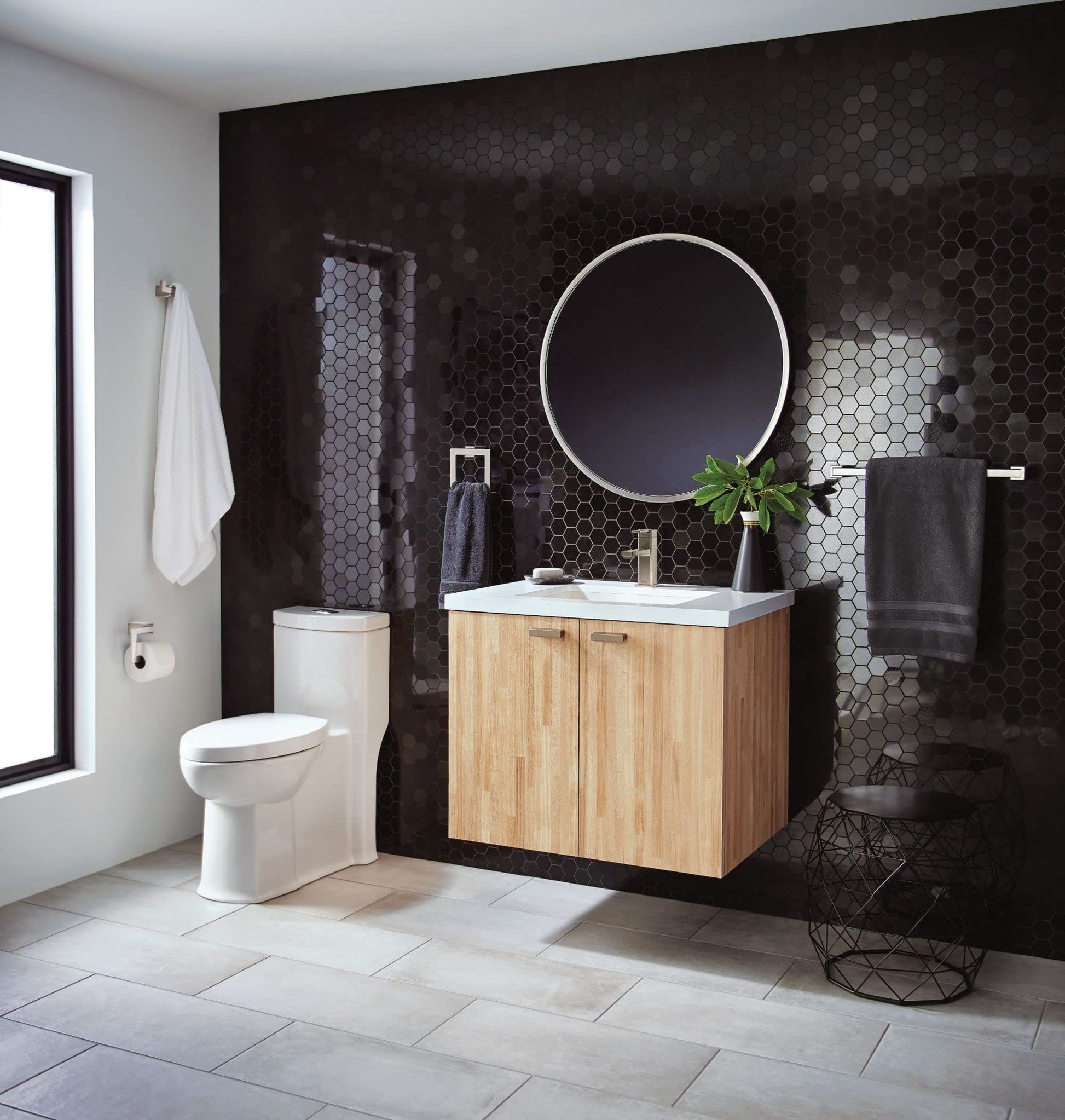 Chrome single-handle faucet with angular spout mounted on white sink in modern bathroom setting.
