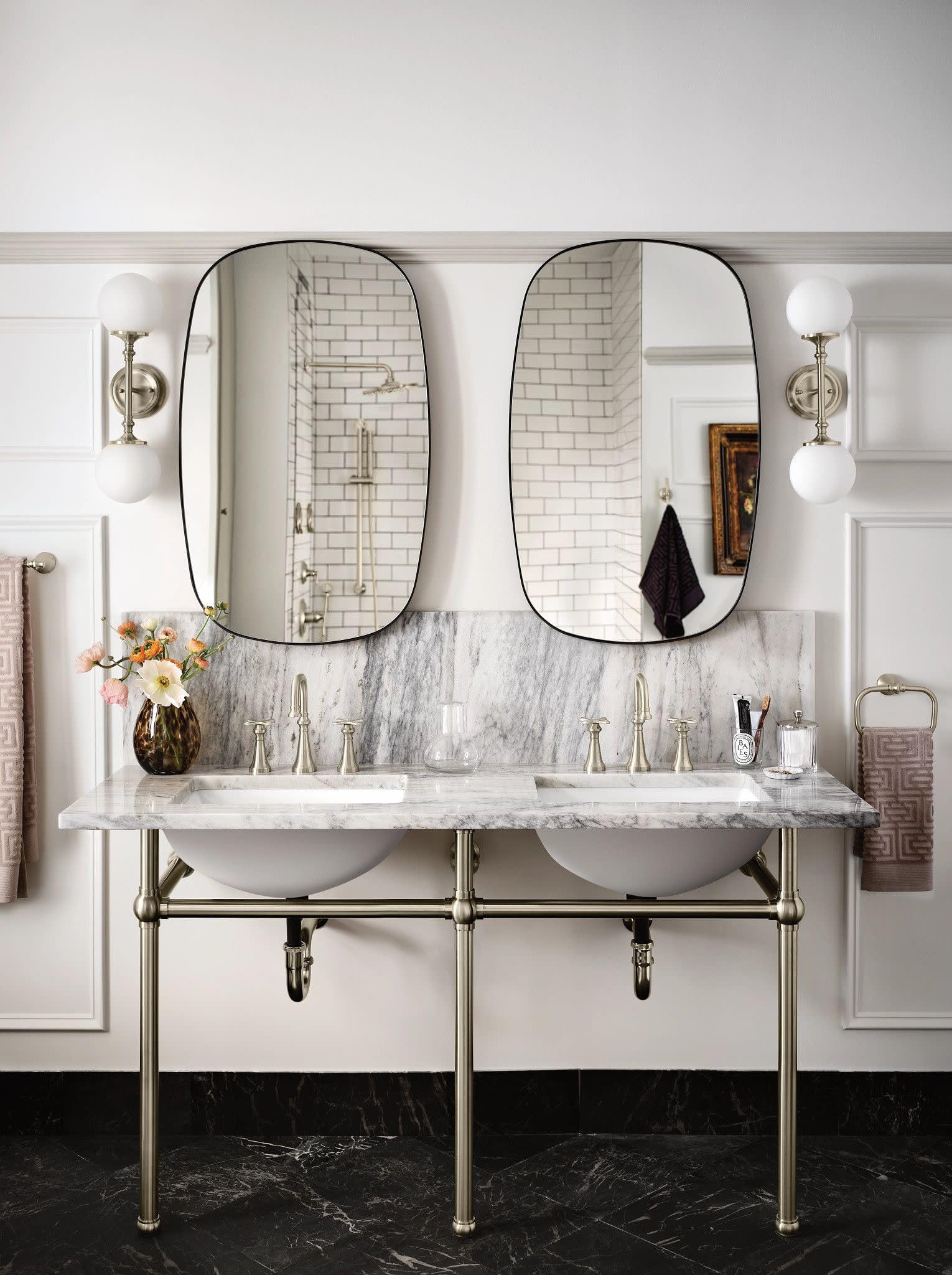 Brushed nickel wall-mounted bathroom faucet trim with traditional cross handles installed above dual white vessel sinks.