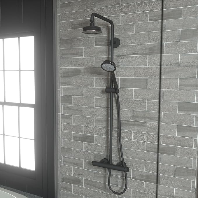Rubbed bronze shower system with overhead showerhead, handheld sprayer, and control valve mounted on tile wall.