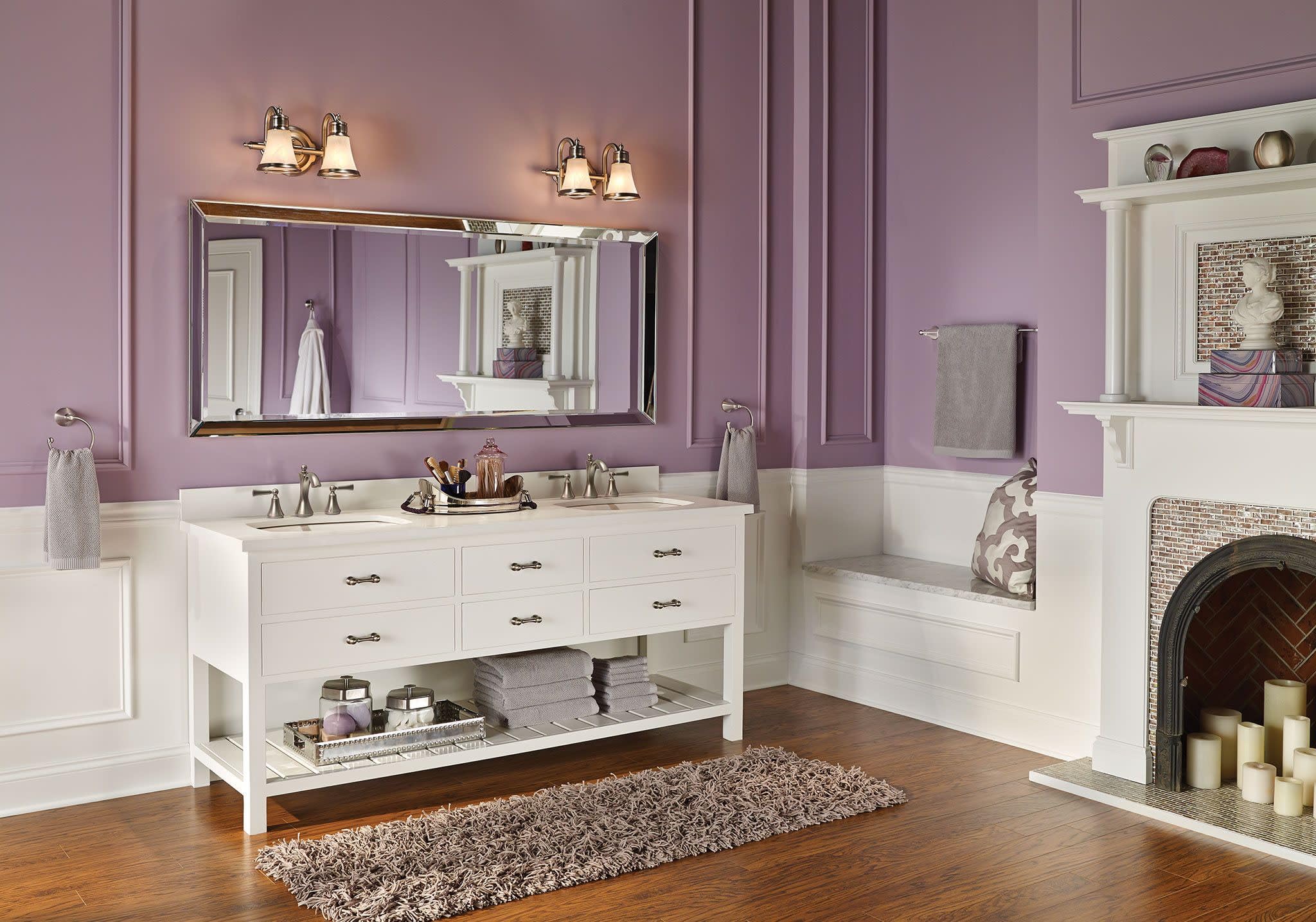 Brushed nickel two-handle widespread bathroom faucet with high arc spout and lever handles installed on white vanity.