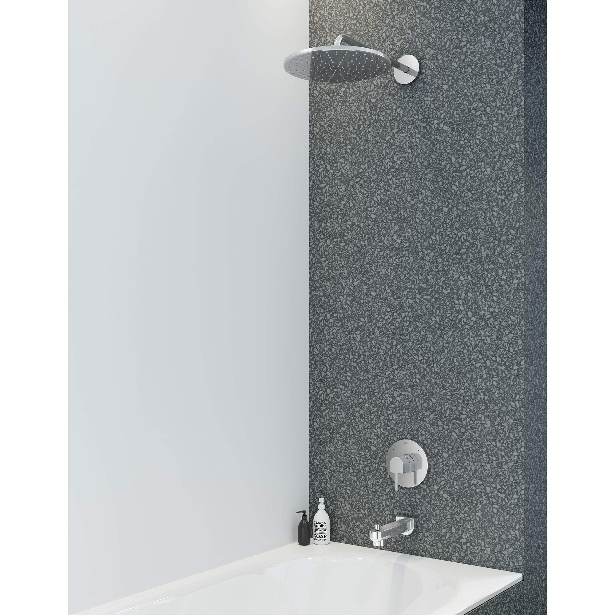 Chrome shower valve trim with round showerhead and single control knob mounted on tile wall above bathtub.