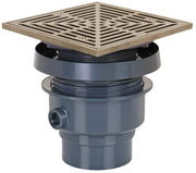 Square nickel bronze drain grate with linear pattern mounted on dark gray PVC drain hub assembly with side outlet.