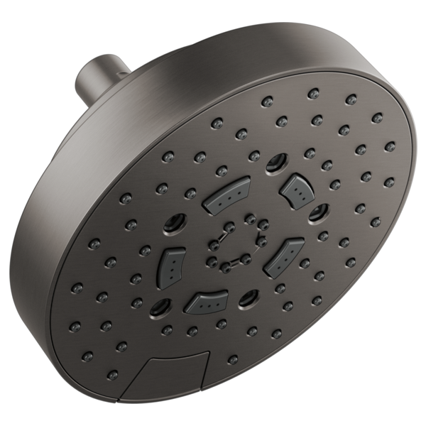 Round brushed metal shower head with multiple spray nozzles and connection arm, mounted in wall position.