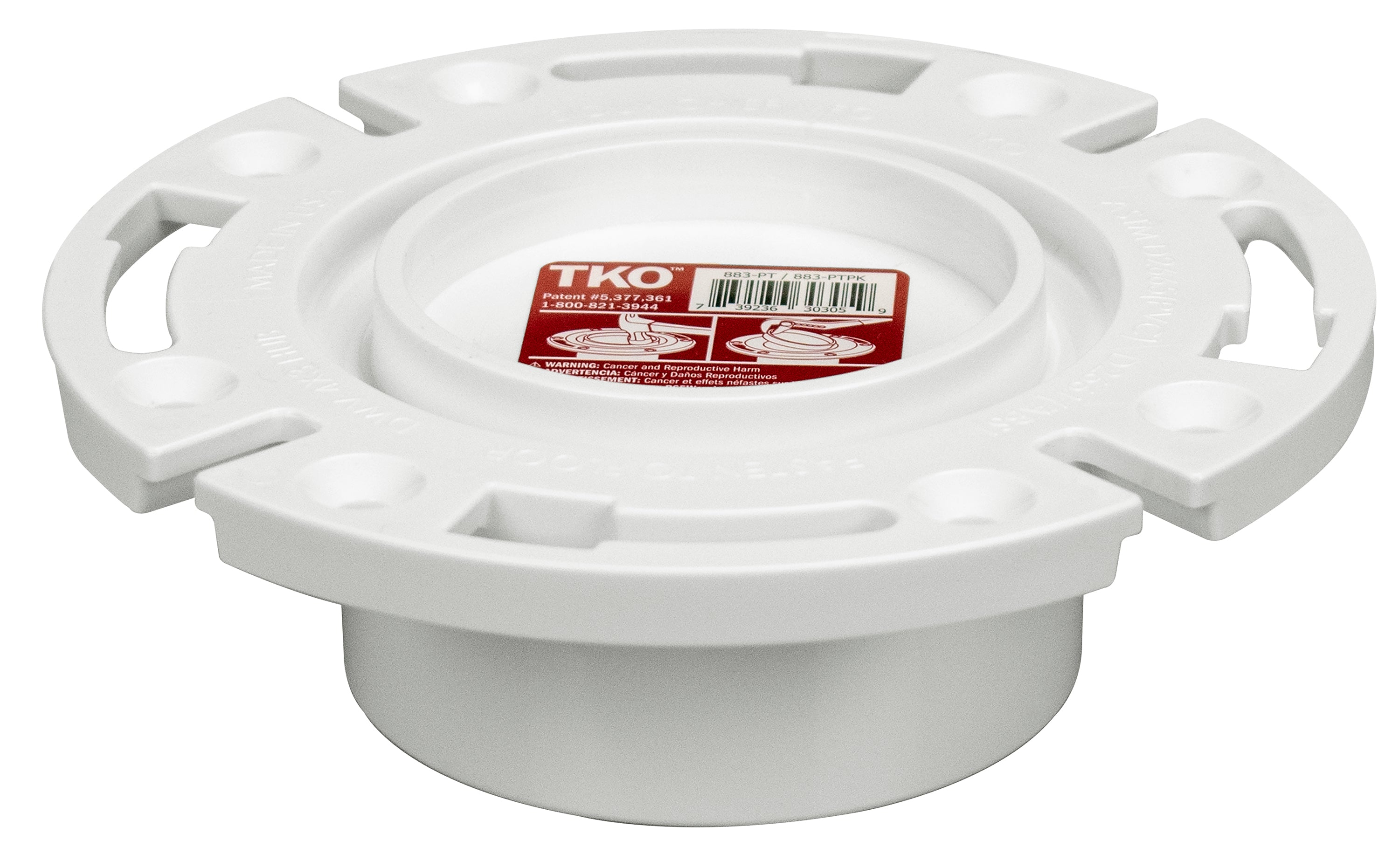 White PVC closet flange with four handles and knockout opening, red label visible on top surface.