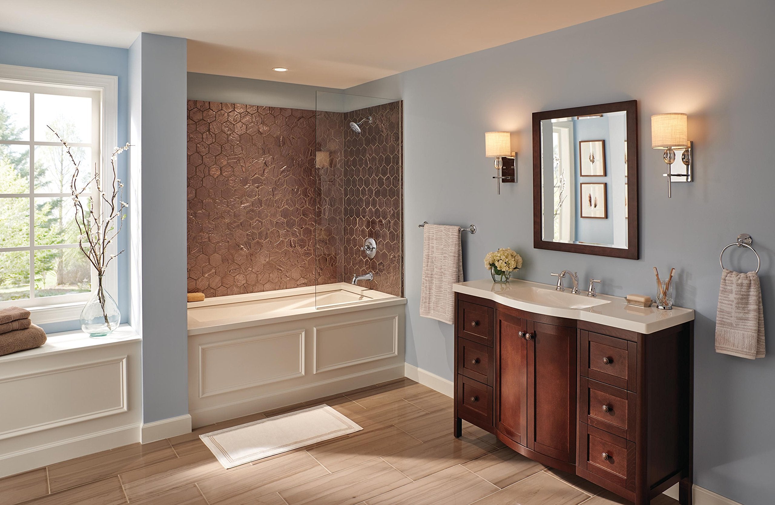 Chrome two-handle widespread bathroom faucet with traditional design installed on dark wood vanity.