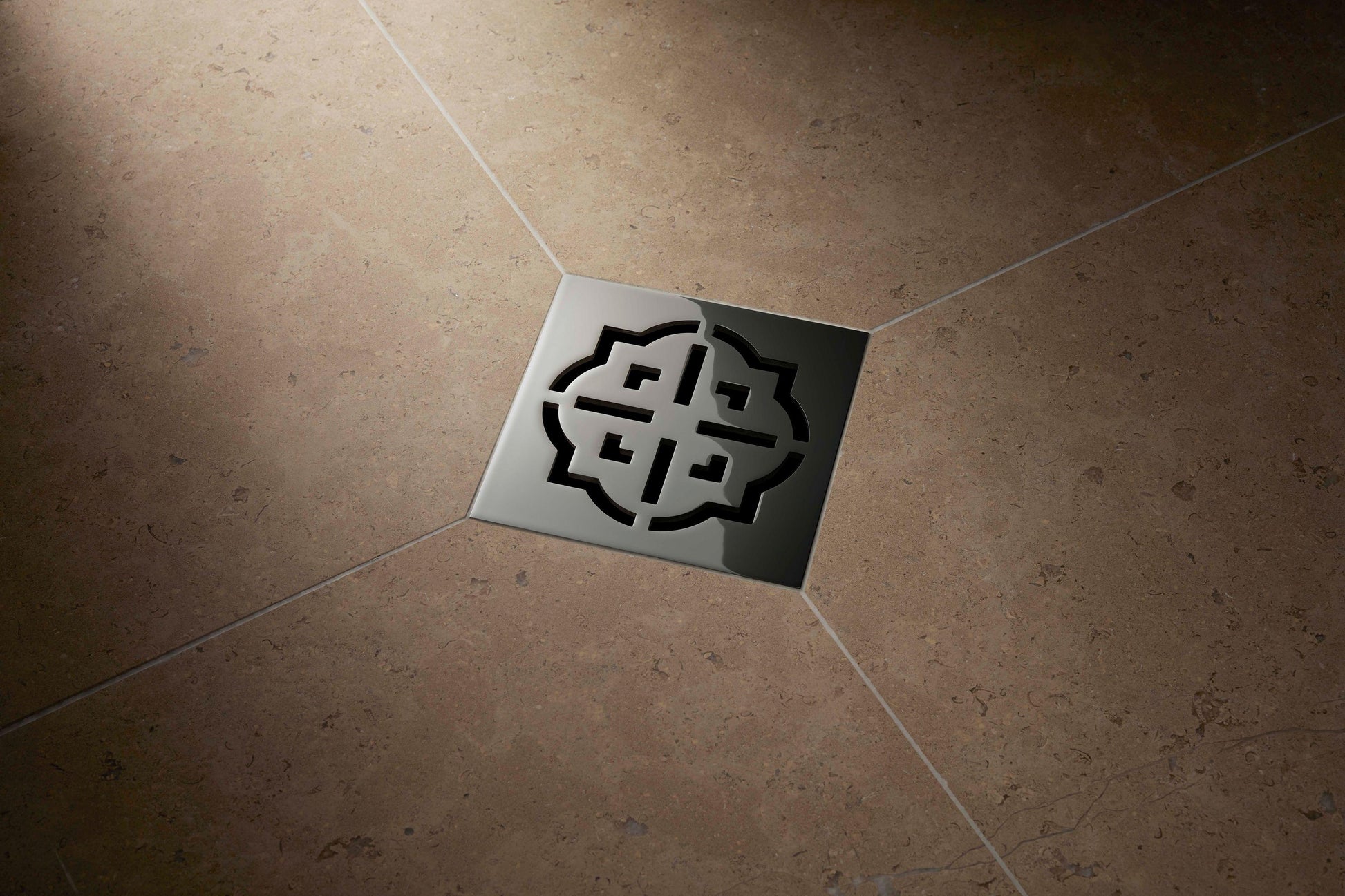 Burnished brass square drain trim with geometric grid pattern installed in tile flooring.
