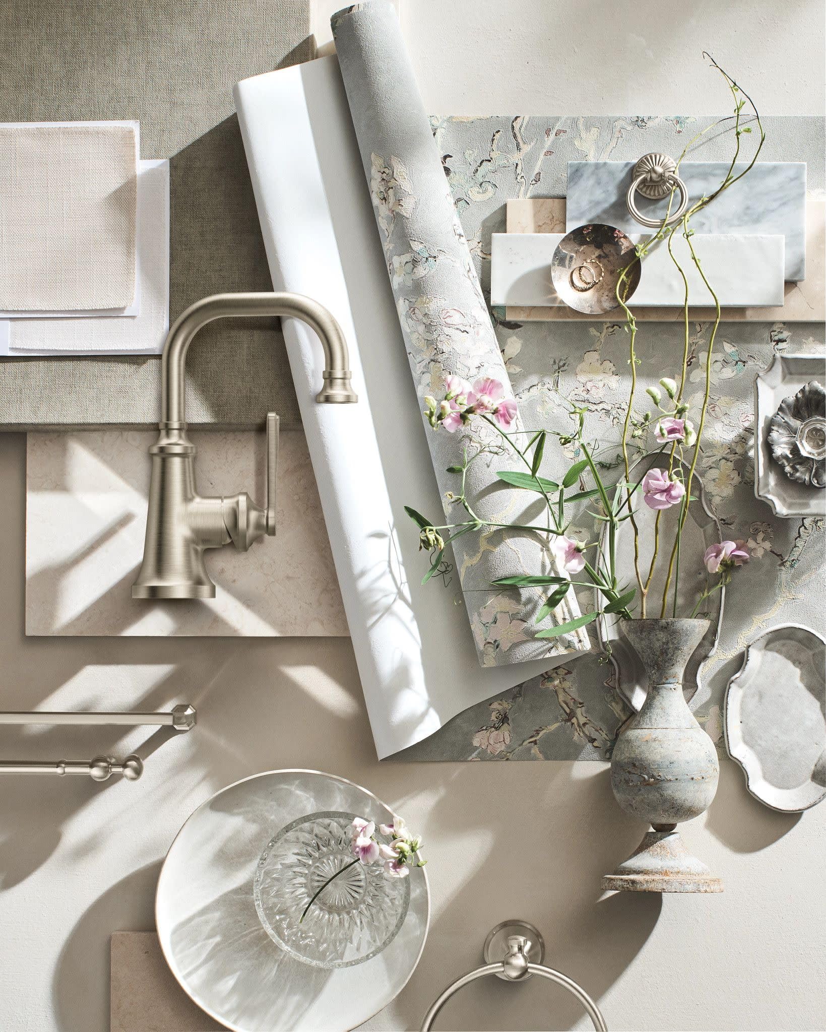 Brushed nickel single-handle bathroom faucet with curved spout and traditional design mounted on white sink.