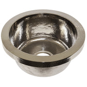 Polished nickel round bar sink with hammered interior and smooth rim, drain hole visible at center bottom.