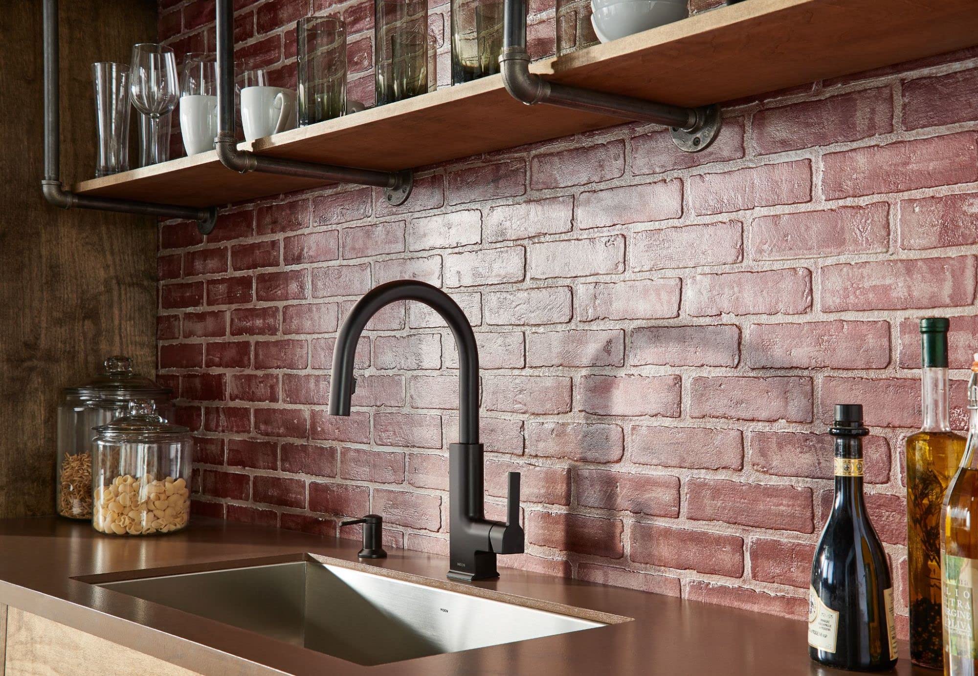 Matte black countertop soap and lotion dispenser with pump mechanism displayed on a bathroom counter.