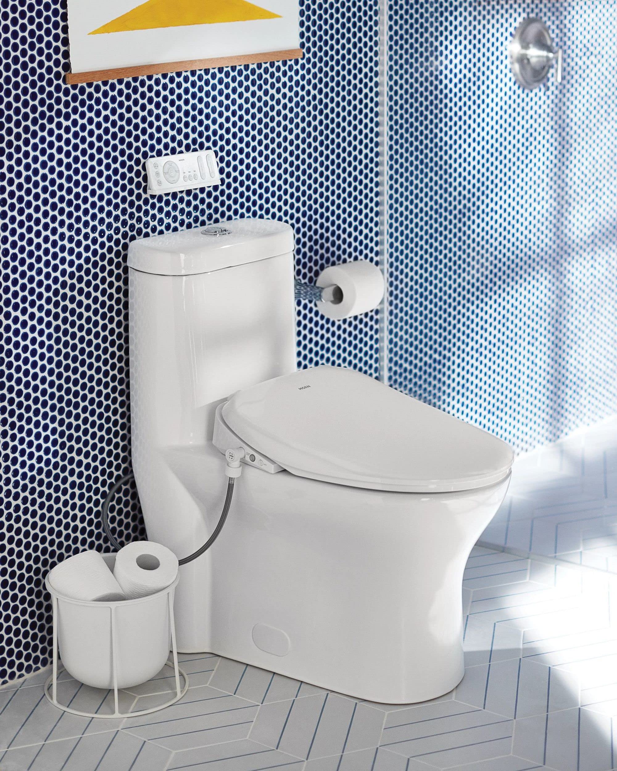 Chrome pivoting toilet paper holder mounted on wall next to white toilet in blue tiled bathroom.