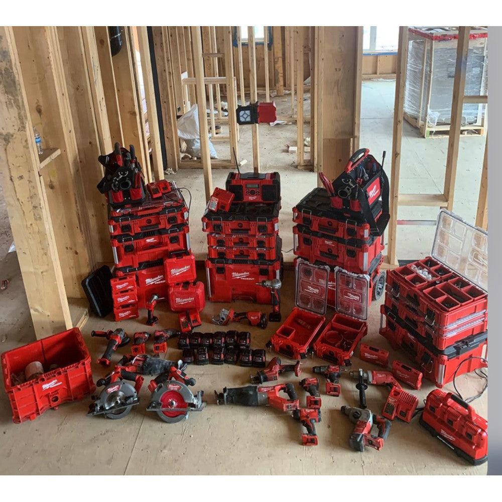 Red and black Milwaukee PACKOUT tote with handles and compartments, displayed among other storage containers and tools.